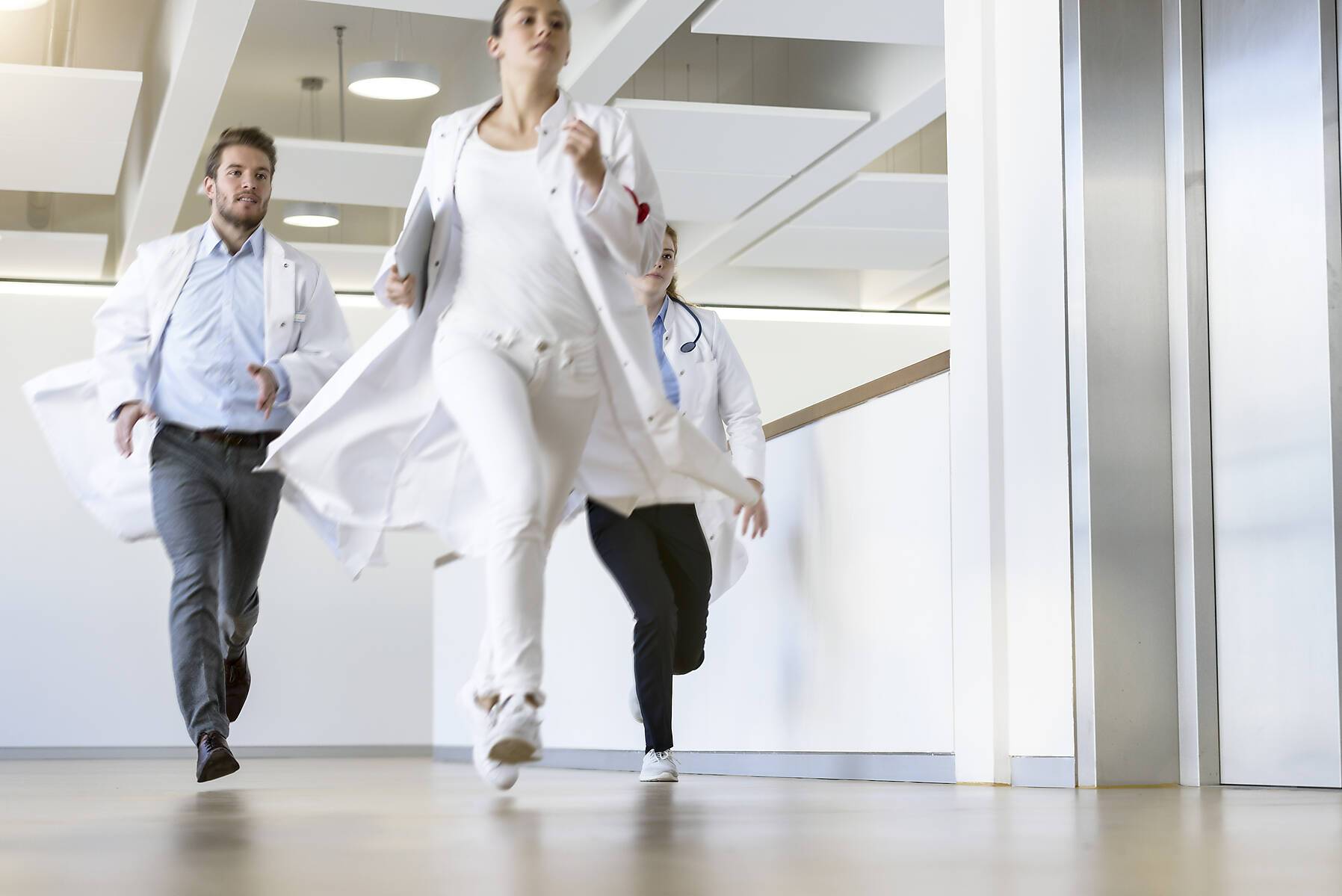 stock image, royalty-free, Male and female doctors running along hospital corridor