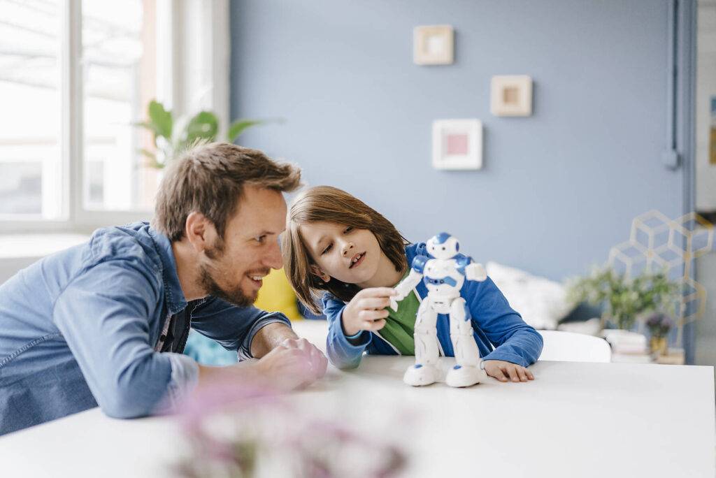 royalty-free, stock image, Happy father and son playing with robot on table at home