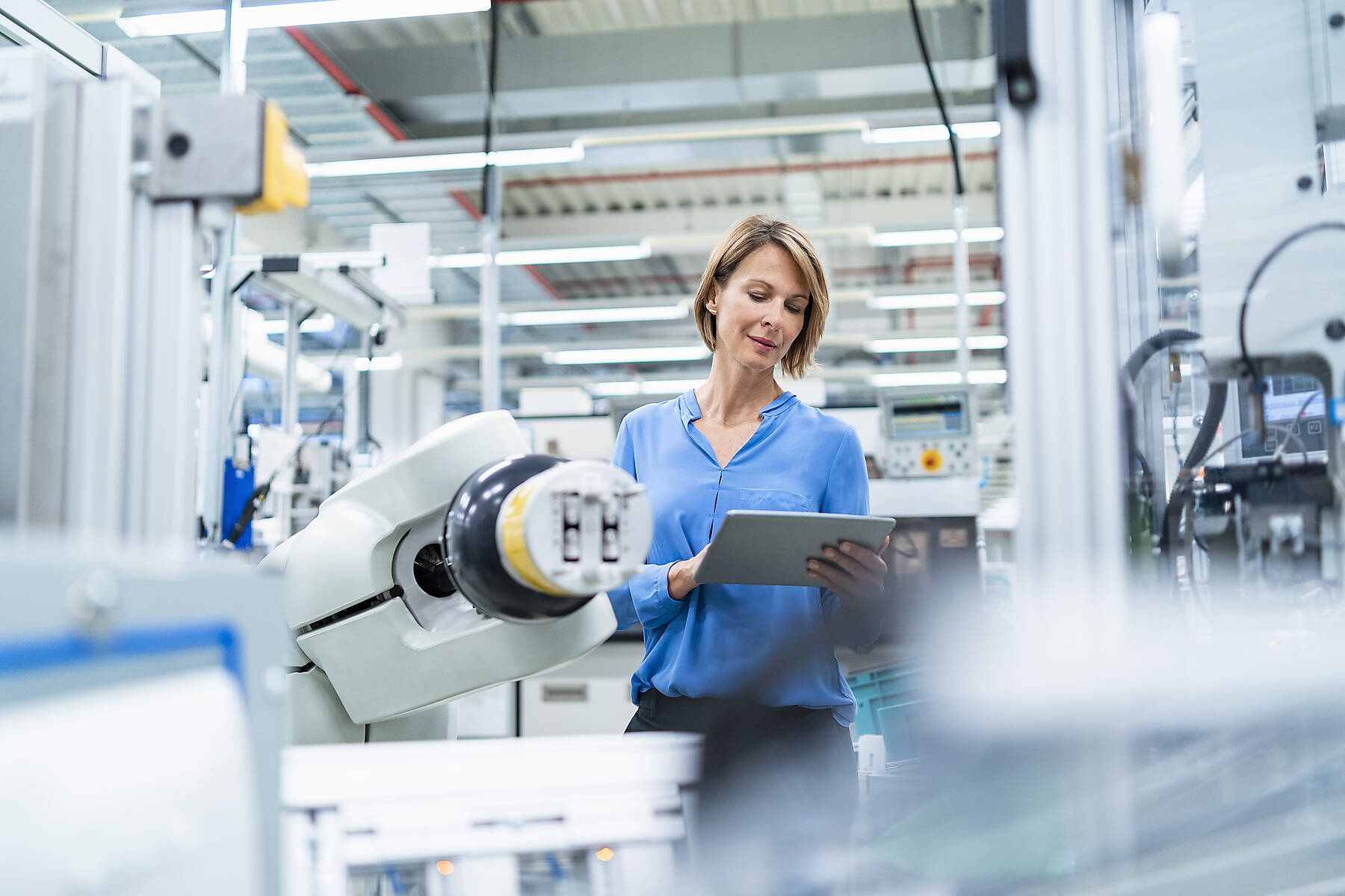 stock image, royalty-free, Businesswoman with tablet at assembly robot in a factory