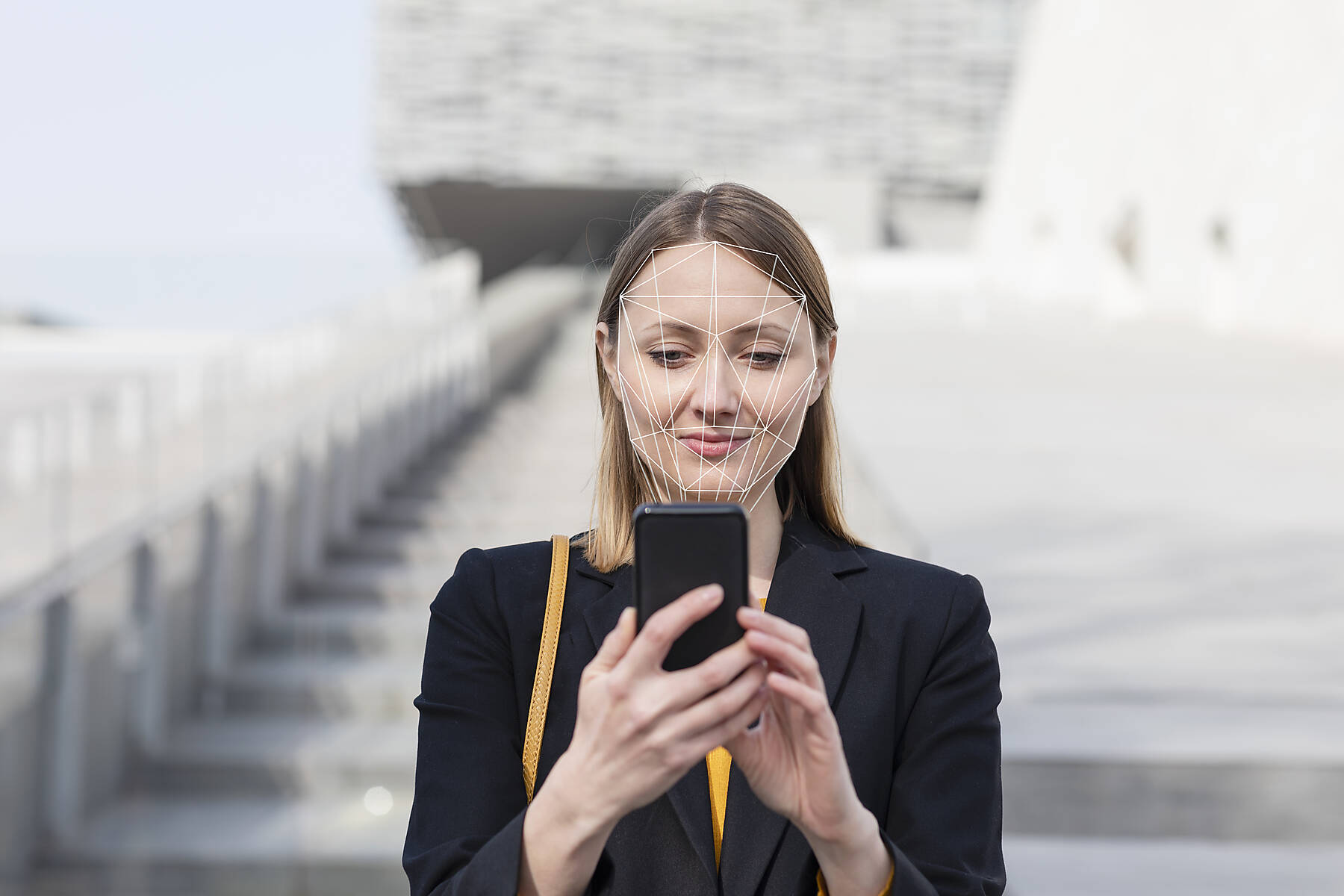 stock image, royalty-free, Businesswoman unlocking mobile phone with face recognition technology while standing outdoors