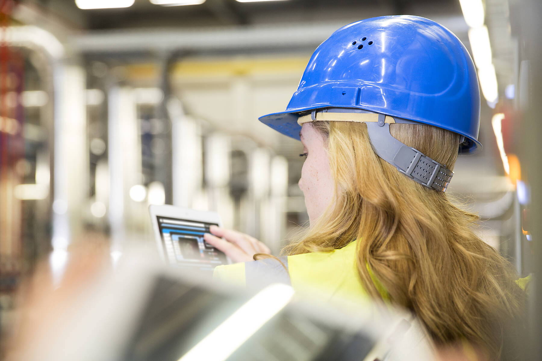 stock image, royalty-free, Woman wearing reflective vest controlling industrial plant with digital tablet