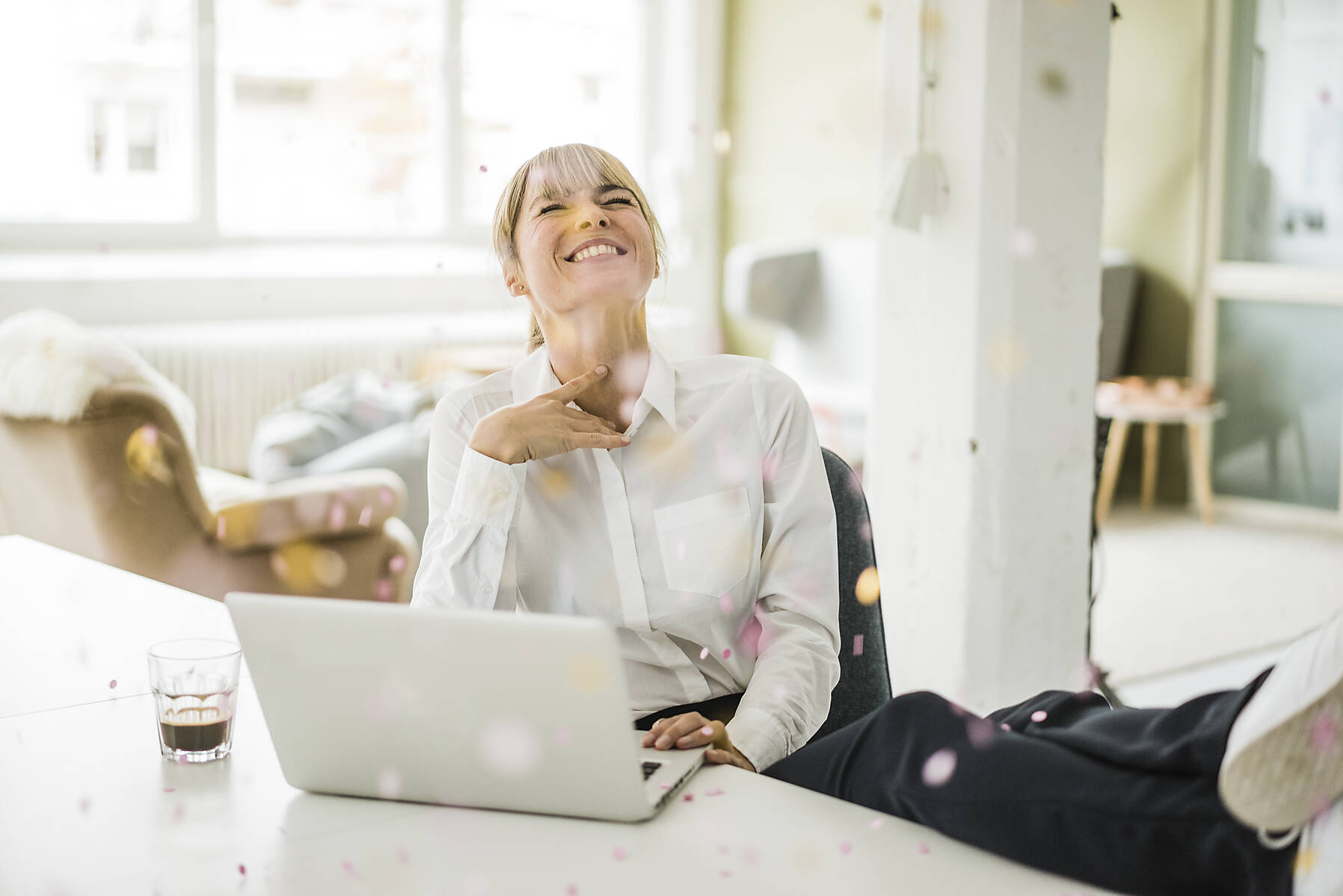 Stockfoto, lizenzfrei, Konfetti fällt auf Geschäftsfrau mit Laptop im Büro