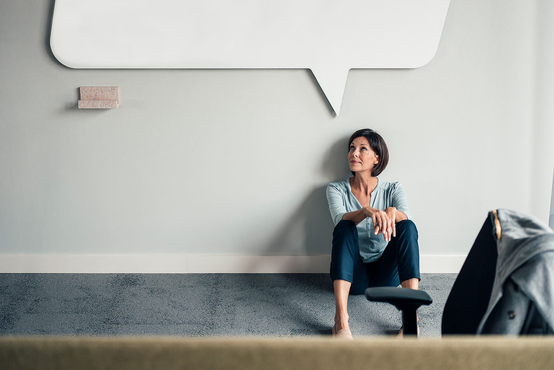 Stockfoto, lizenzfrei, Nachdenklich Geschäftsfrau schaut auf, während auf dem Boden im Büro sitzen