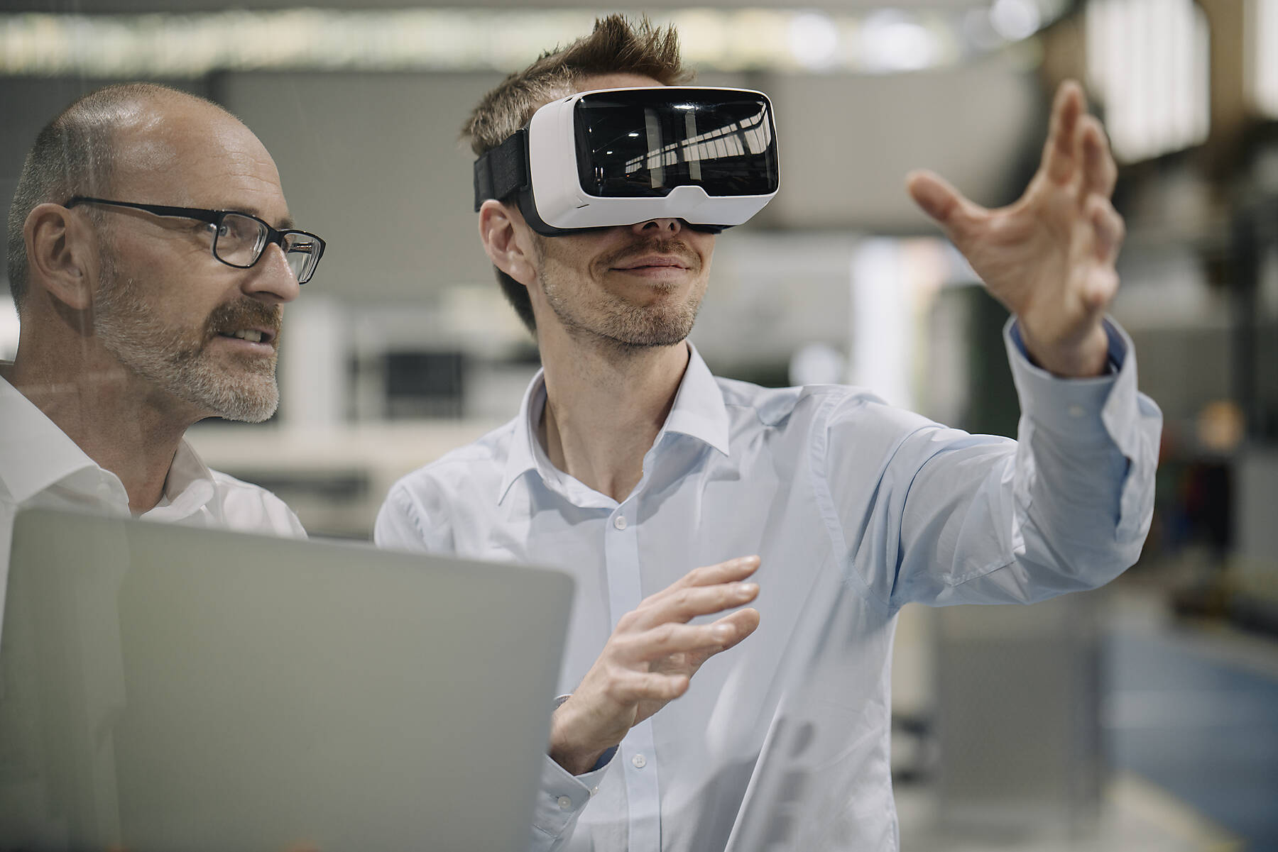 Two men with VR glasses in factory, stock image, royalty-free