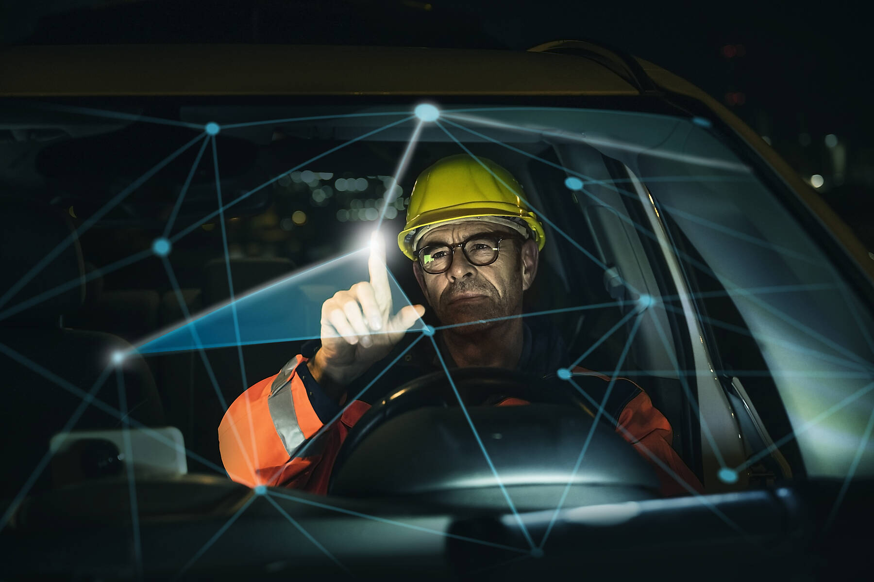 stock image, royalty-free, Engineer wearing hardhat working on augmented graph seen through car windshield