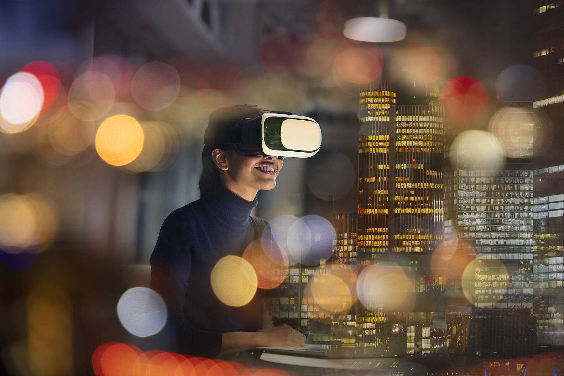 Stockfoto, lizenzfrei, Geschäftsfrau mit Virtual-Reality-Brille in einem Hochhausbüro bei Nacht