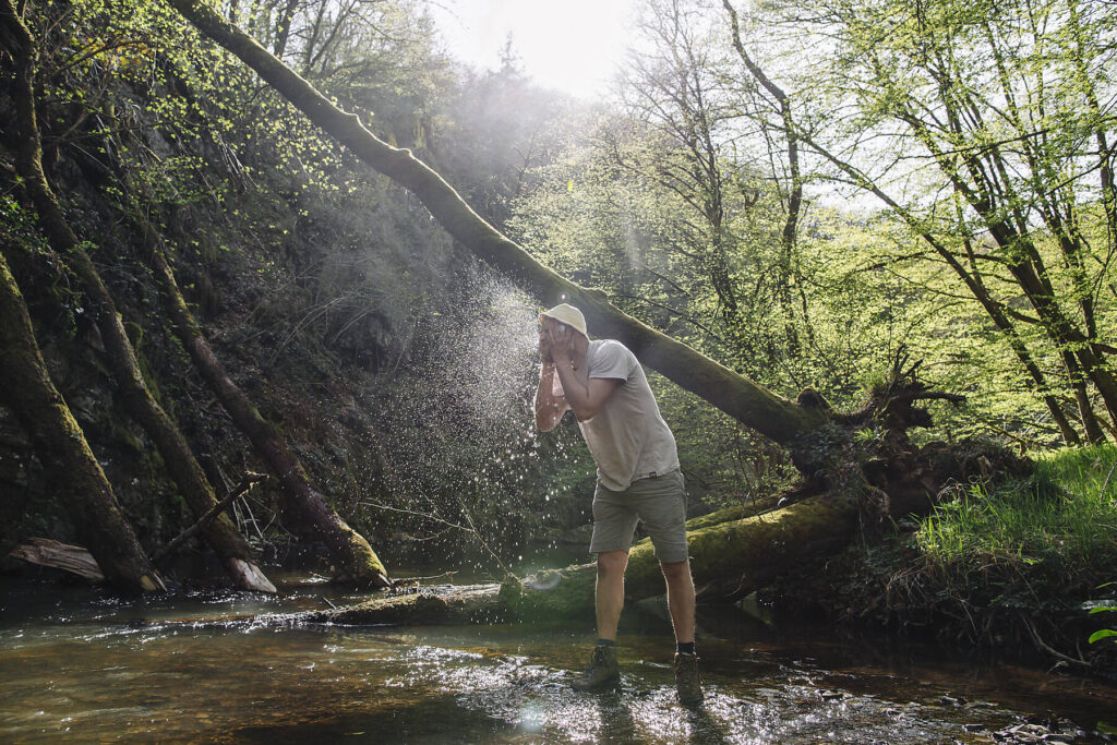 Stockfoto, lizenzfrei, Eskapismus, Junger Mann wäscht sich am Seeufer das Gesicht, Eifel, Vulkaneifel, Rheinland-Pfalz, Deutschland, Natur, Outdoor, Wandern, Wald, m29, Naturbursche, Hiking, Abenteuer