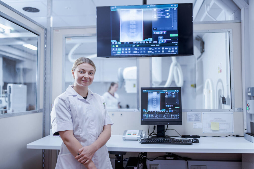 Stockfoto, lizenzfrei, Porträt eines Radiologen mit aufgestelltem Röntgengerät im Krankenhaus