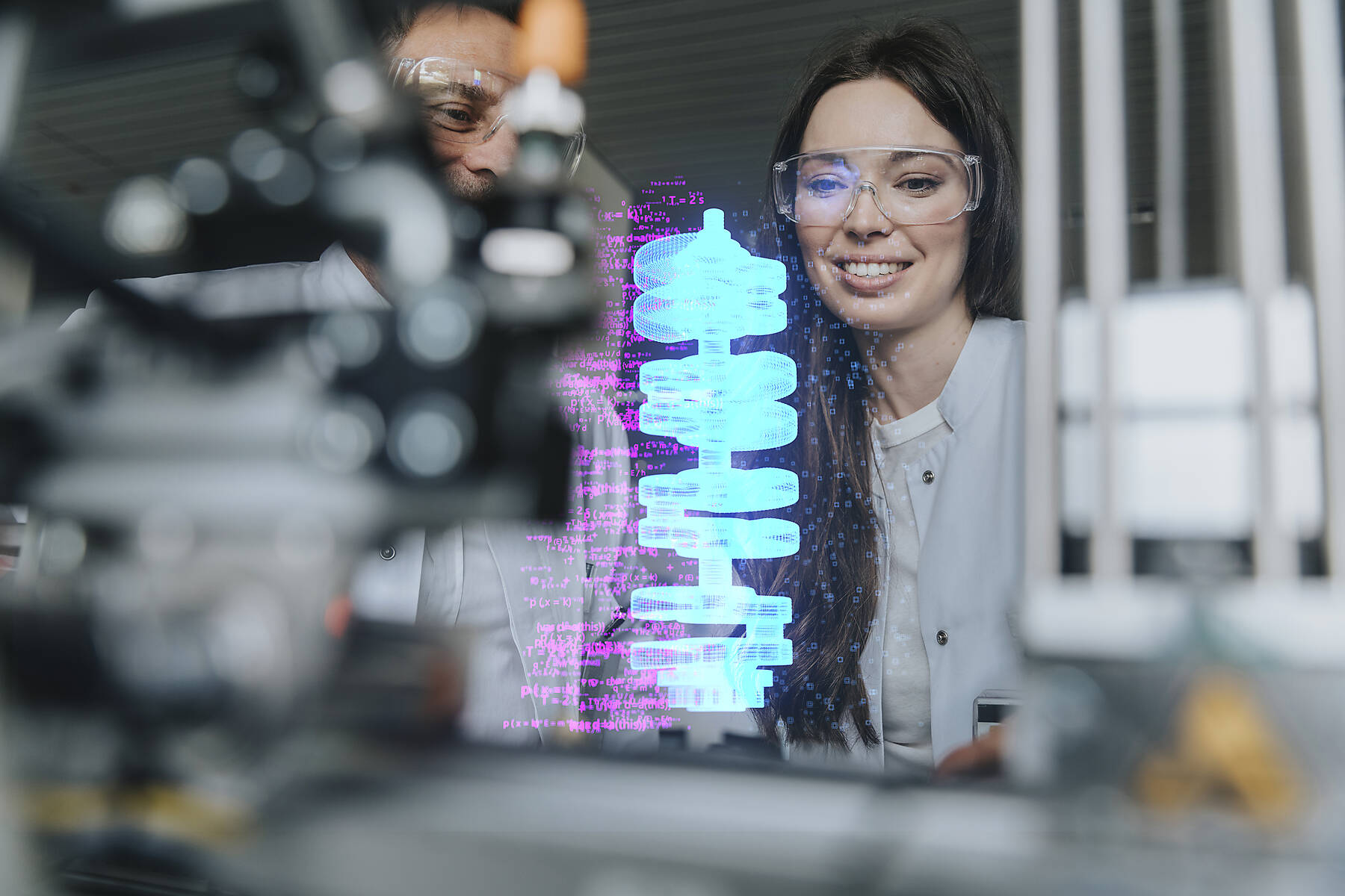 Stockfoto, lizenzfrei, Lächelnde weibliche und männliche Ingenieure bei der Untersuchung futuristischer Automatisierung im Labor