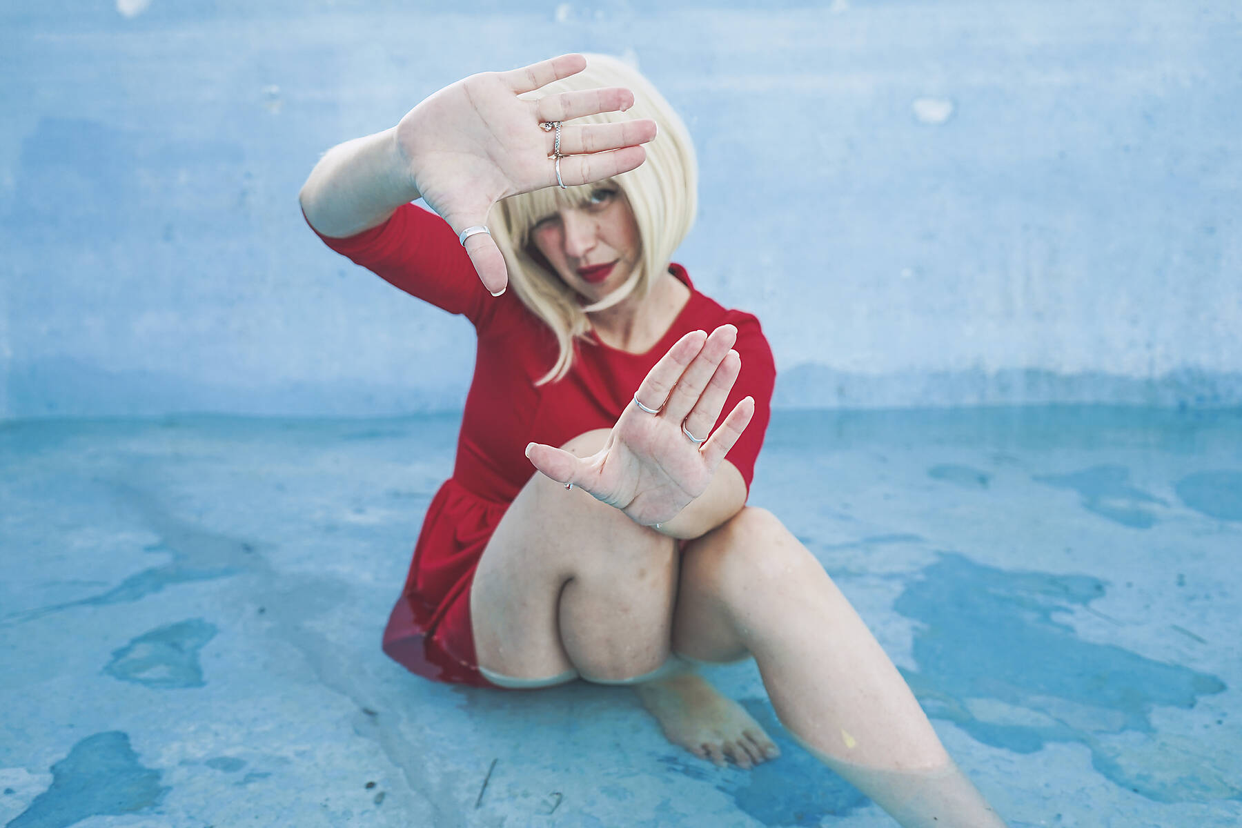 stock image, royalty-free, Woman sitting in swimming pool making finger frame