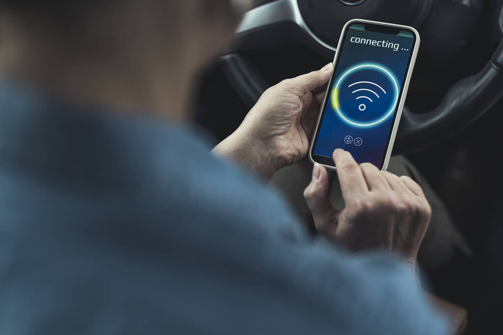 Stockfoto, lizenzfrei, Frau verbindet Smartphone mit Wifi im Auto