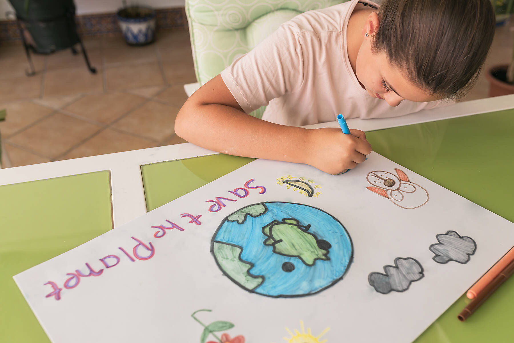 Stock image, royalty-free, Girl making poster of environmental issues at home