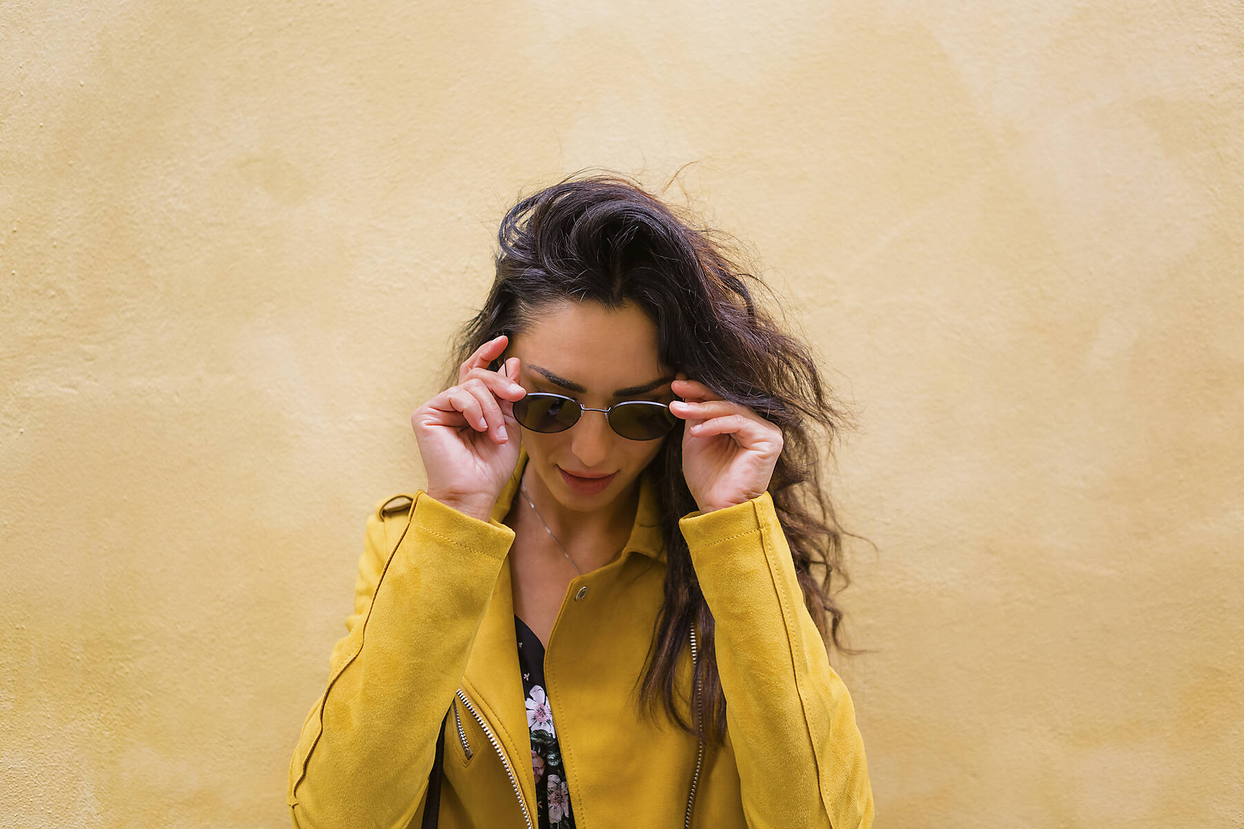 Portrait of young woman wearing yellow leather jacket and sun glasses, stock image, royalty-free,