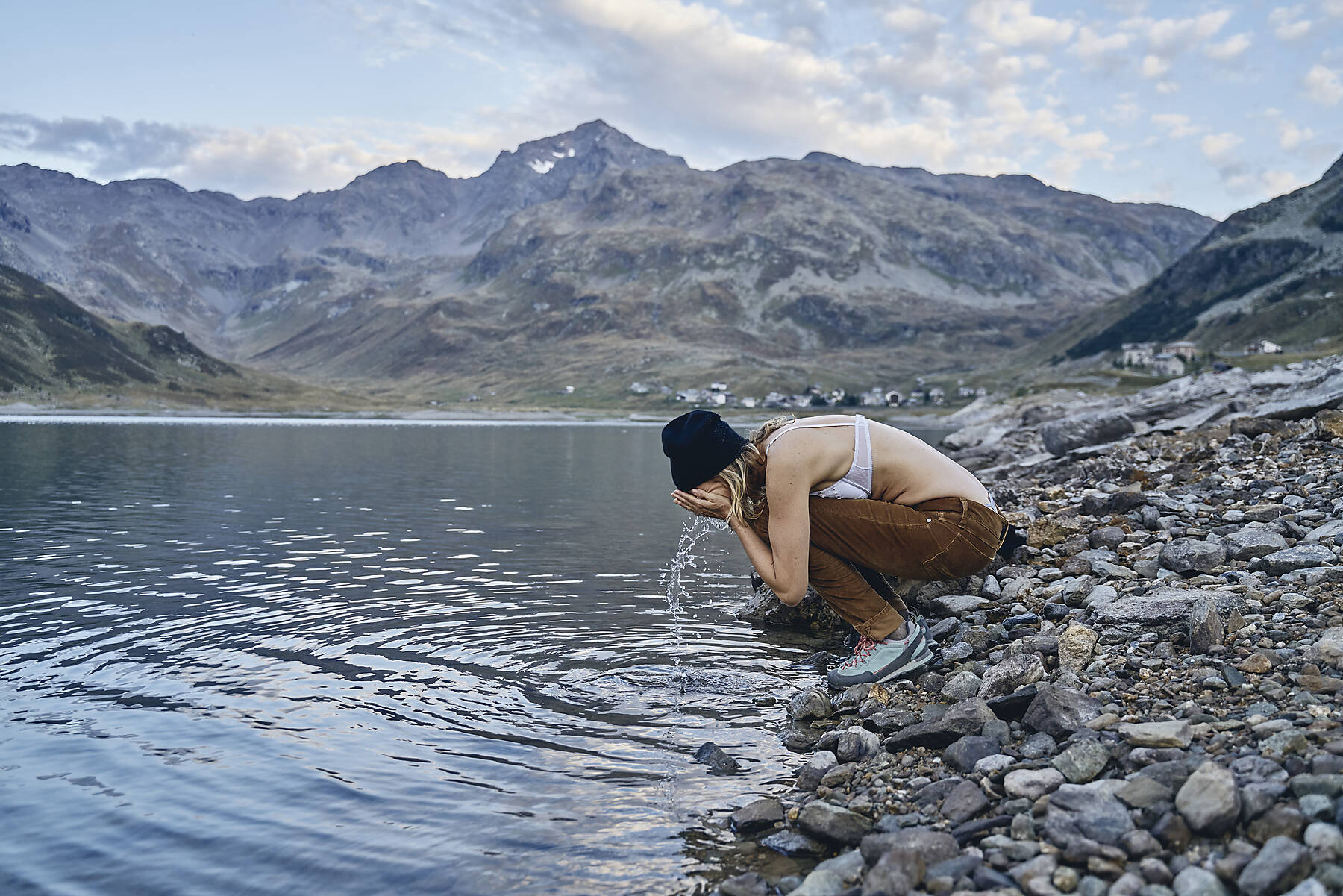 stockfoto, lizenzfrei, Frau wäscht sich das Gesicht am Seeufer, Splugenpass, Sondrio, Italien
