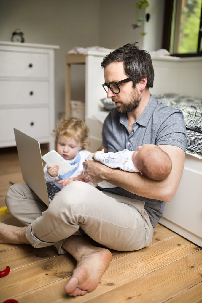 Stockfoto, lizenzfrei,vertikale Bilder, Stories, Storytelling, mobile-first, Vater mit seinem kleinen Sohn und seiner kleinen Tochter, die von zu Hause aus arbeiten