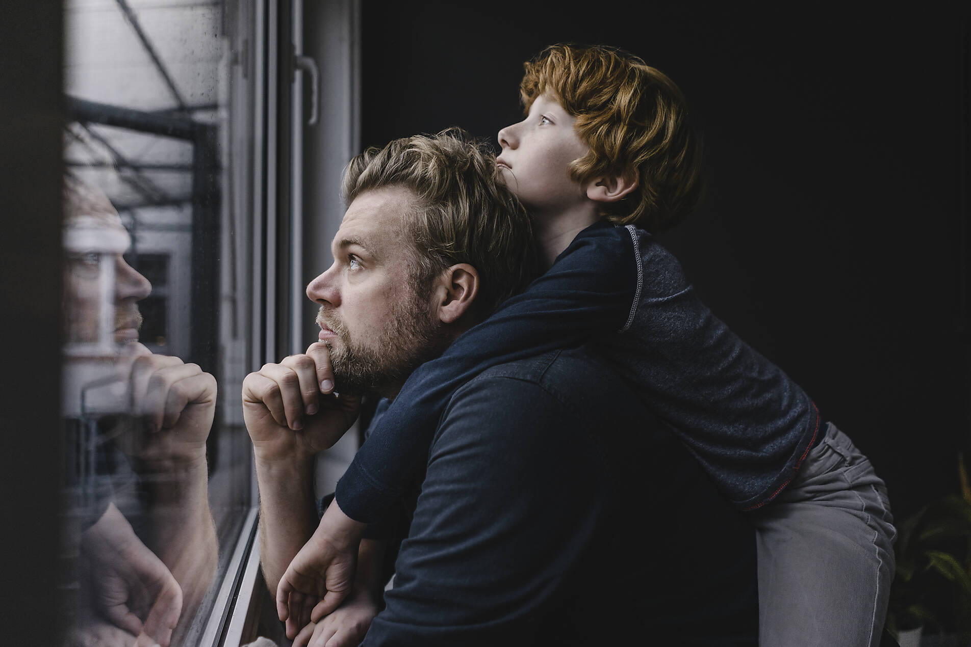 Stockfoto, lizenzfrei, Vater und Sohn schauen an einem regnerischen Tag aus dem Fenster