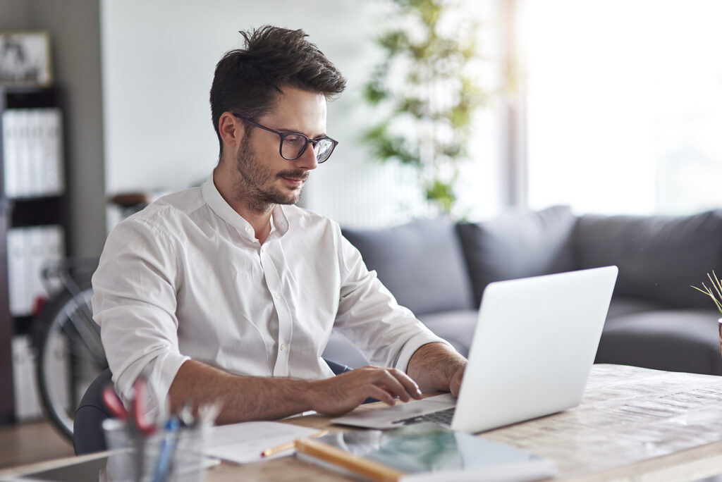 Stock image, royalty-free, Businessman working on laptop at home office, new work, white shirt, glasses,