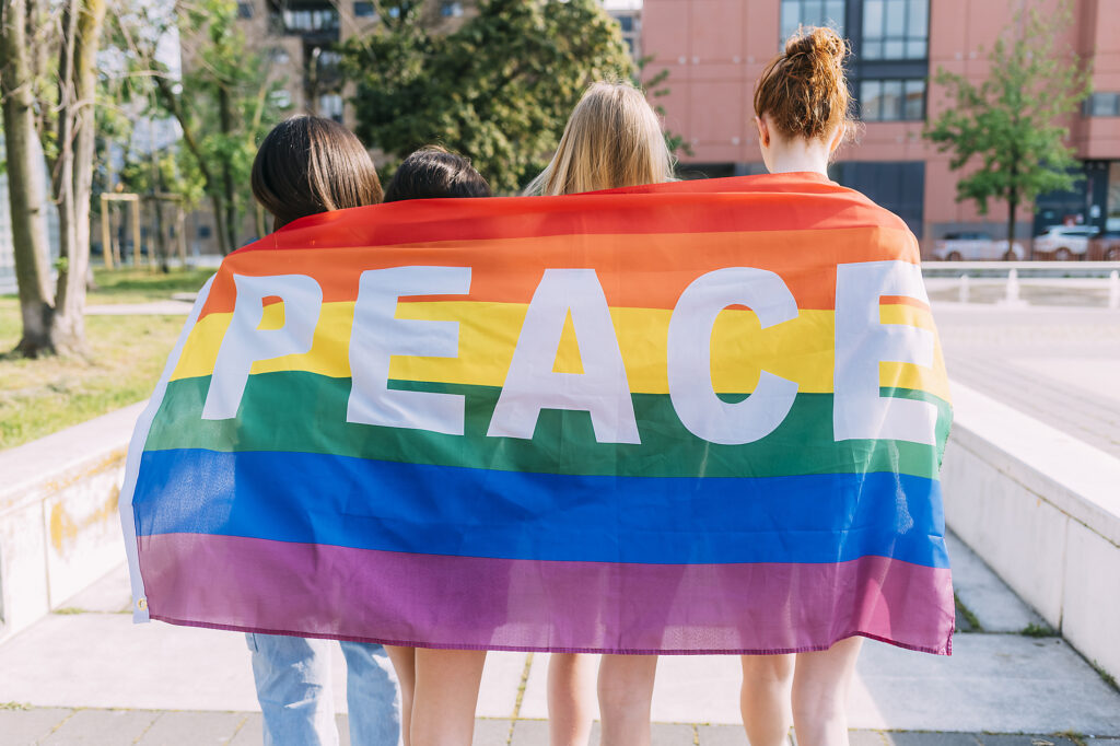 Stockfoto, lizenzfrei, vier Mädchen mit Peace-Flagge, Diversity, Freundschaft, Sommer,