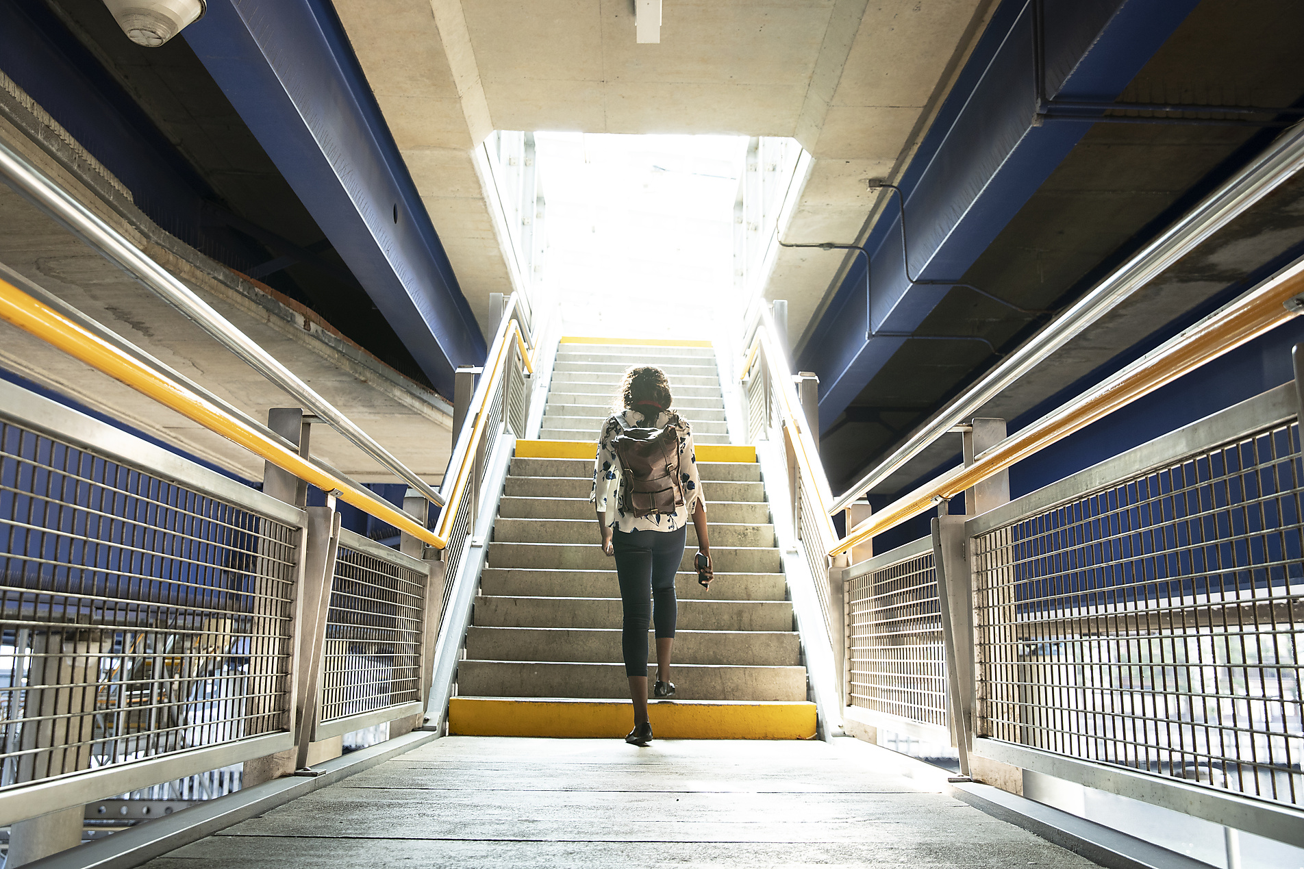 Stockfoto, lizenzfrei, Geschäftsfrau mit Rucksack zu Fuß auf Stufen in der U-Bahn
