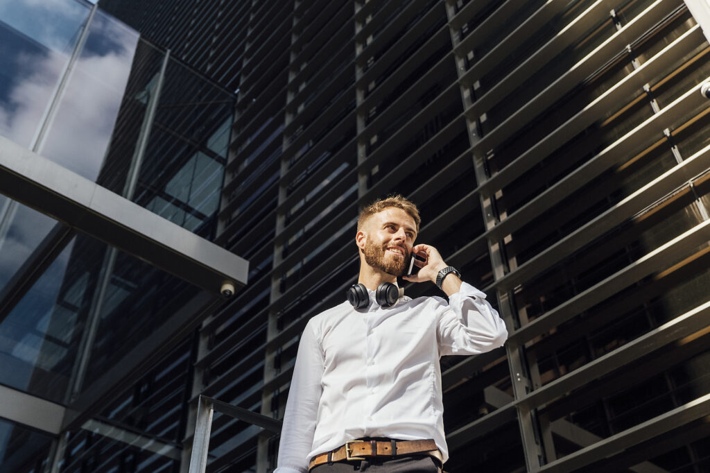stock image, royalty-free, homepage header, Businessman talking on mobile phone while standing against building