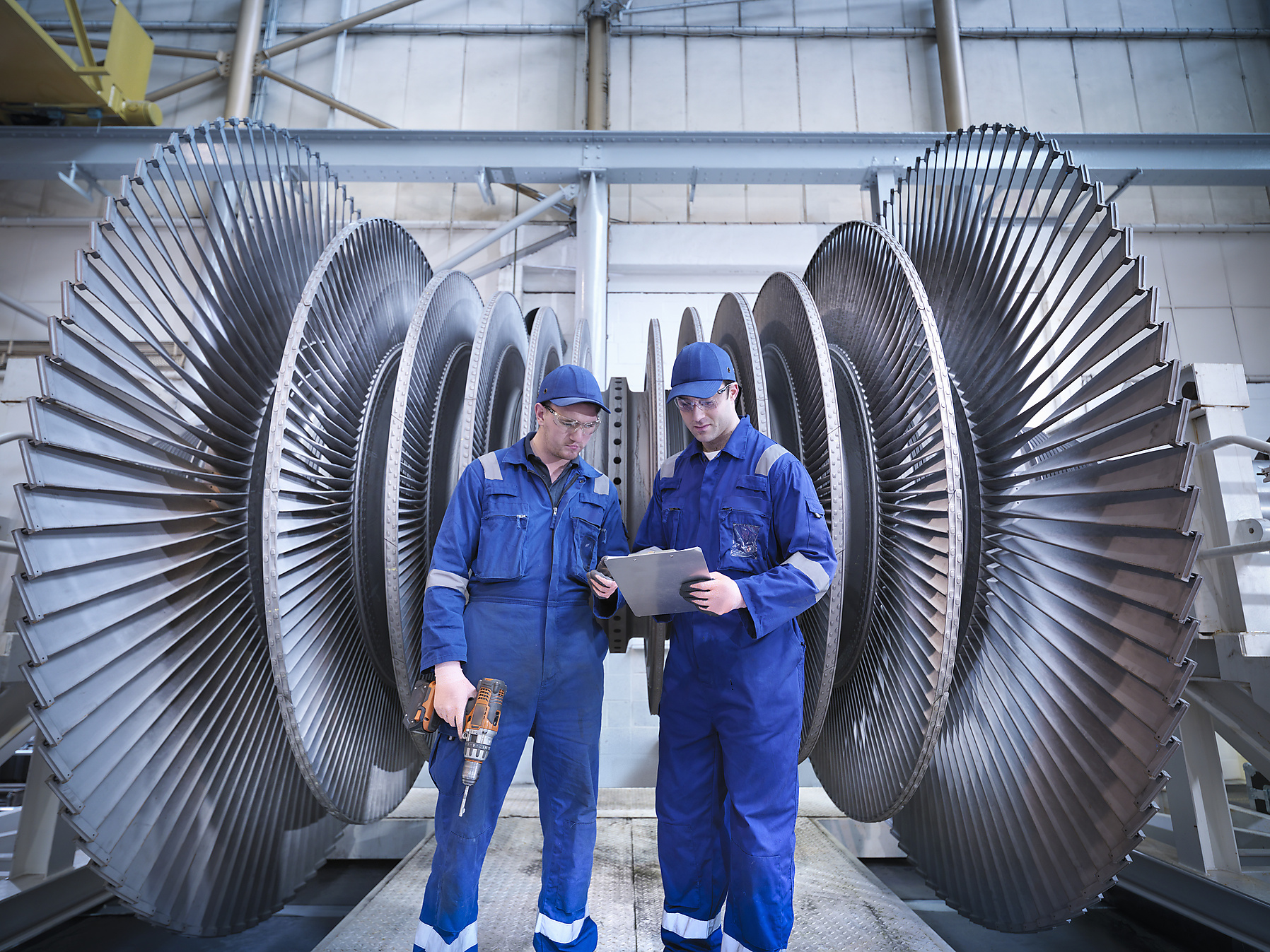 Stock photo, royalty free, engineers discuss in front of a steam turbine in a factory hall, climate positive, hydro energy, renewable energy, energy transition