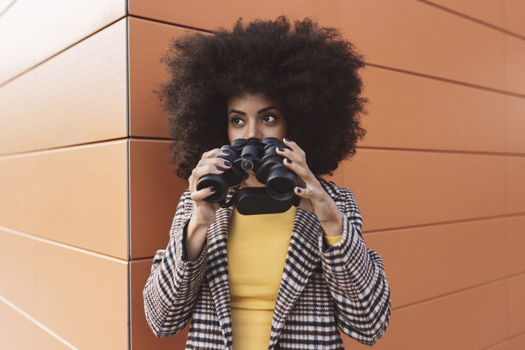 stock images, royalty-free, Jose Carlos Ichiro, Woman with binoculars in front of wall