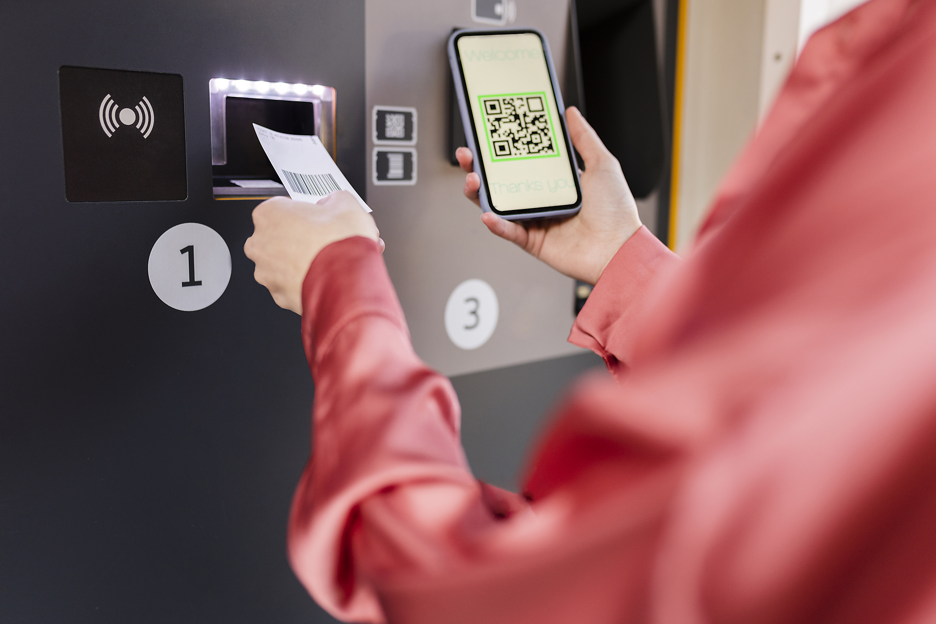 Stock image, royalty-free, Woman scanning QR code on ticket machine through smart phone at station