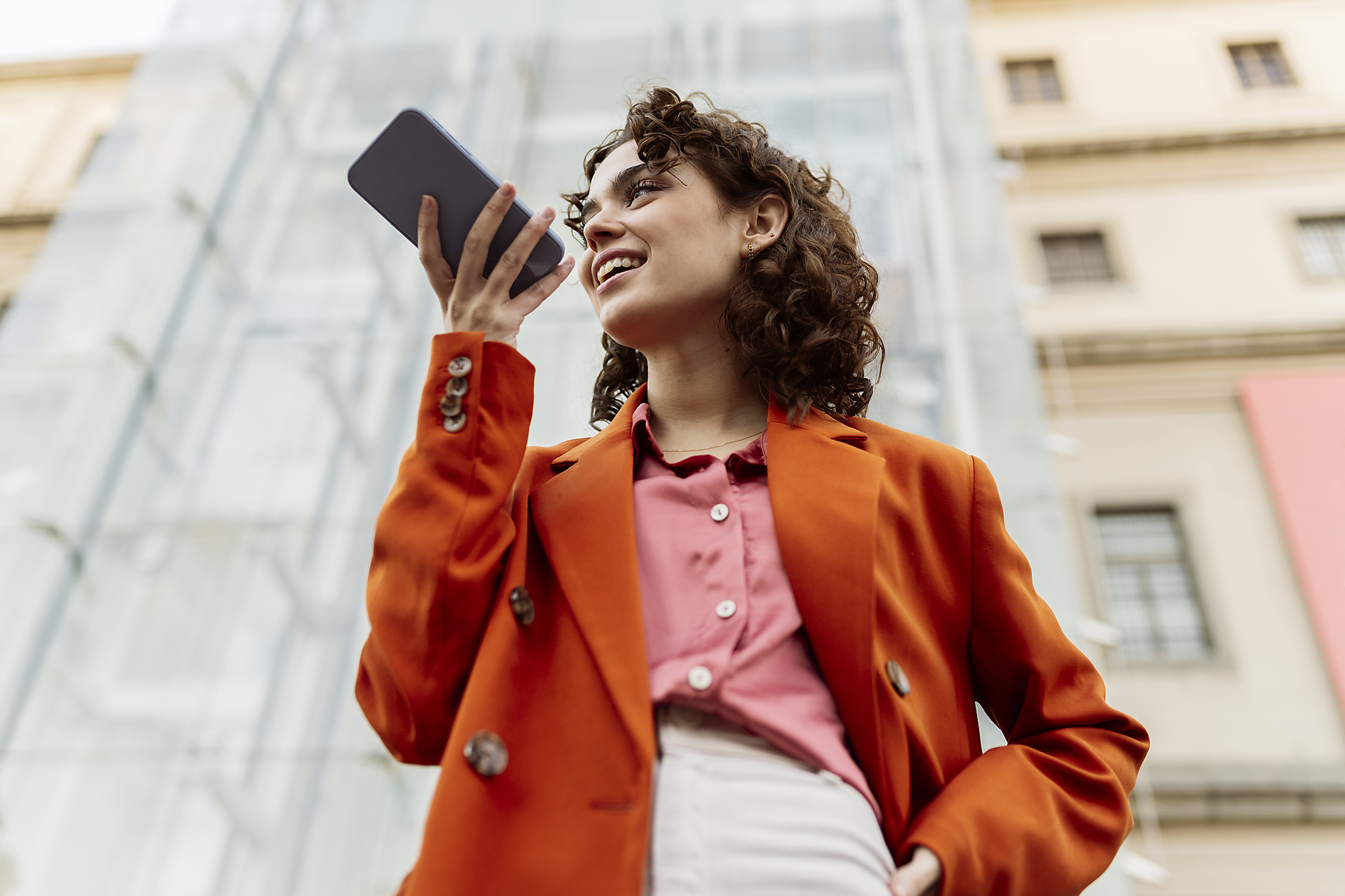 stock photo, royalty-free, Young woman sending voicemail through smart phone in city