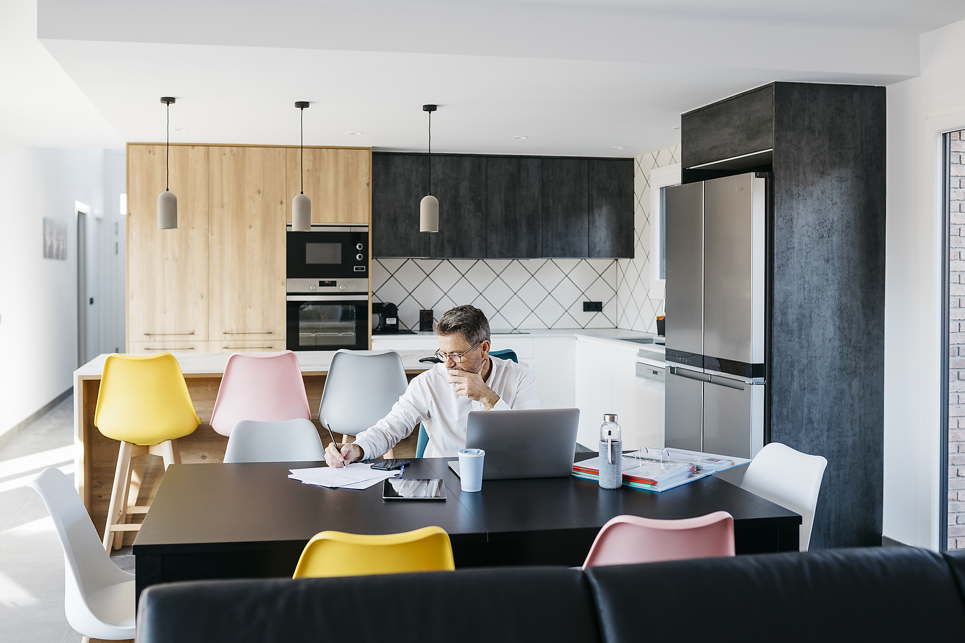 Stock image, royalty-free, Male freelance worker writing business strategy while sitting at table in home office, new work,