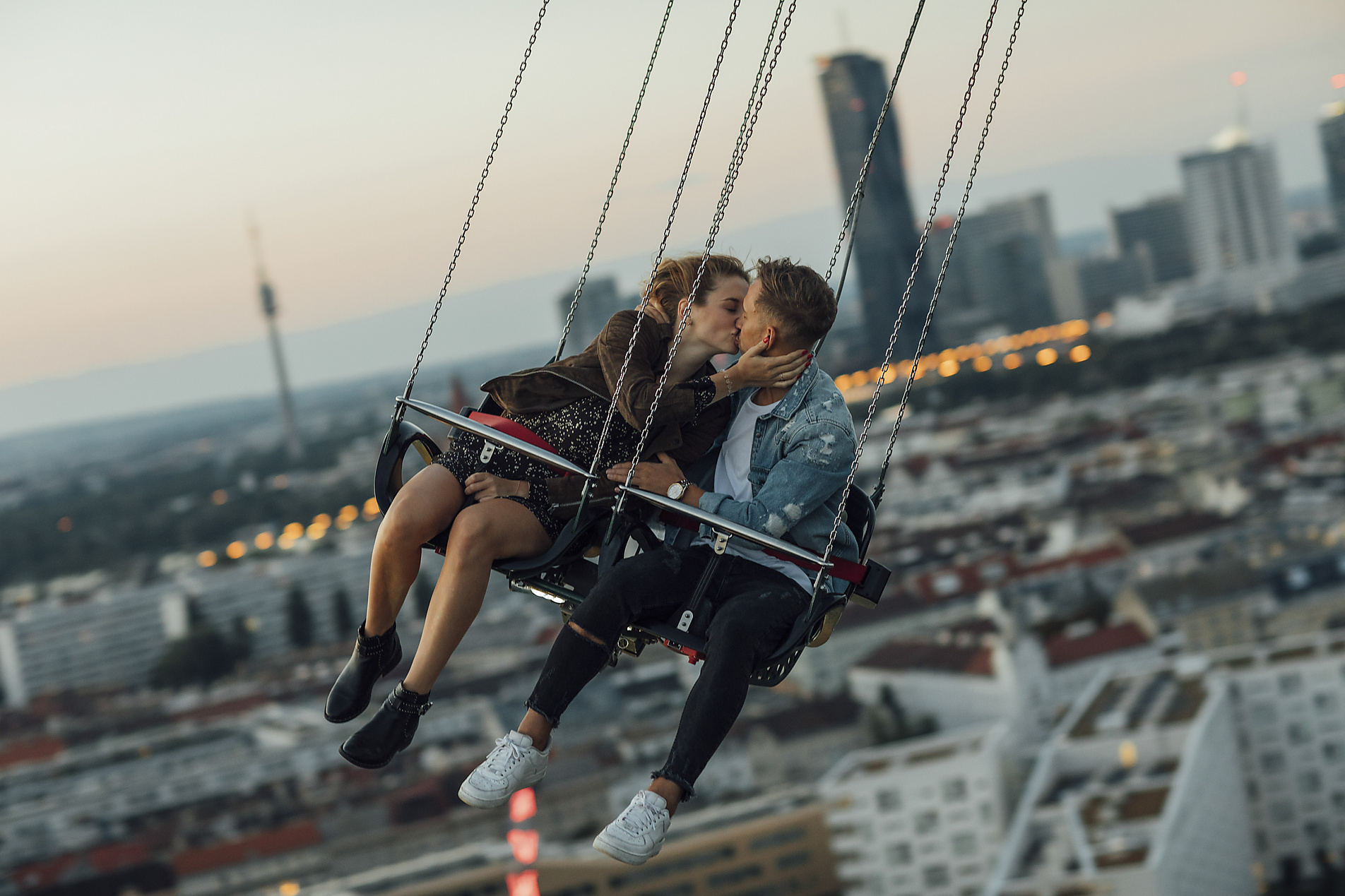 Stock image, royalty-free, Young couple in love, riding chairoplane on a fairground, Kissing,