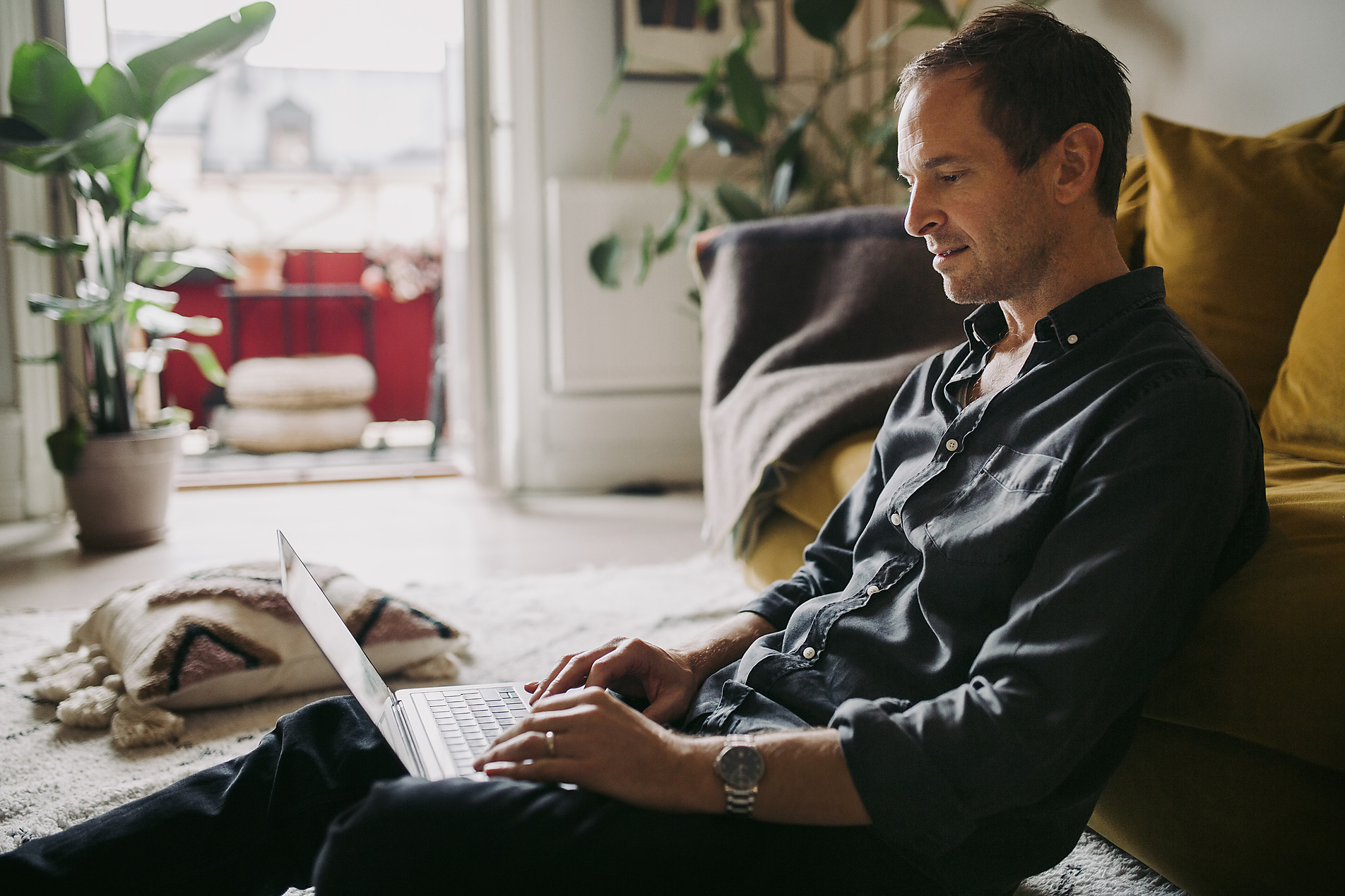 Stock image, royalty-free, Male entrepreneur working on laptop in living room during pandemic New Work