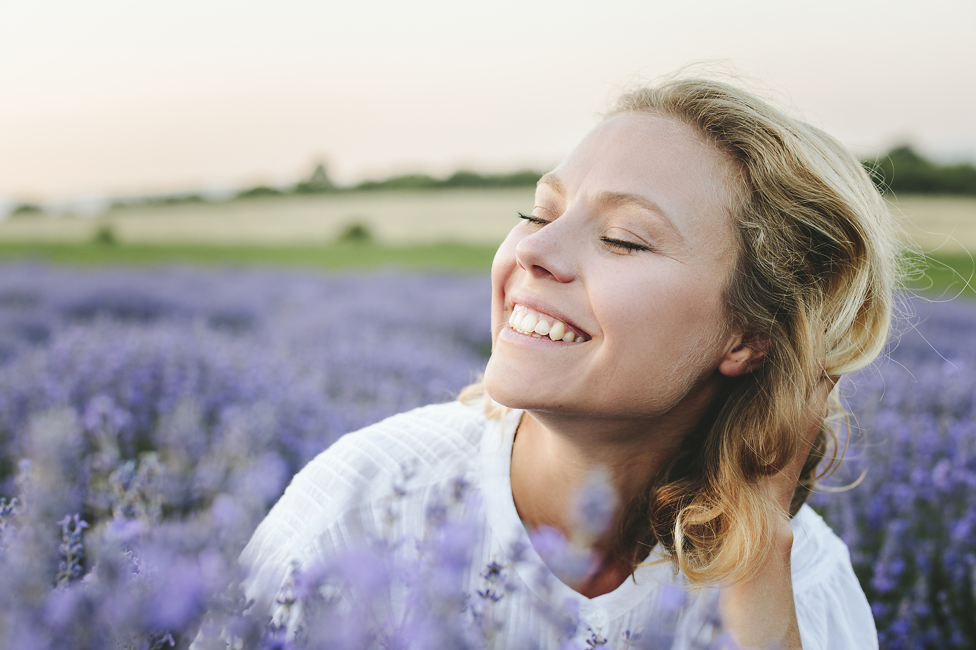 stock photo, royalty-free, Cheerful woman with blond hair amidst lavender plants