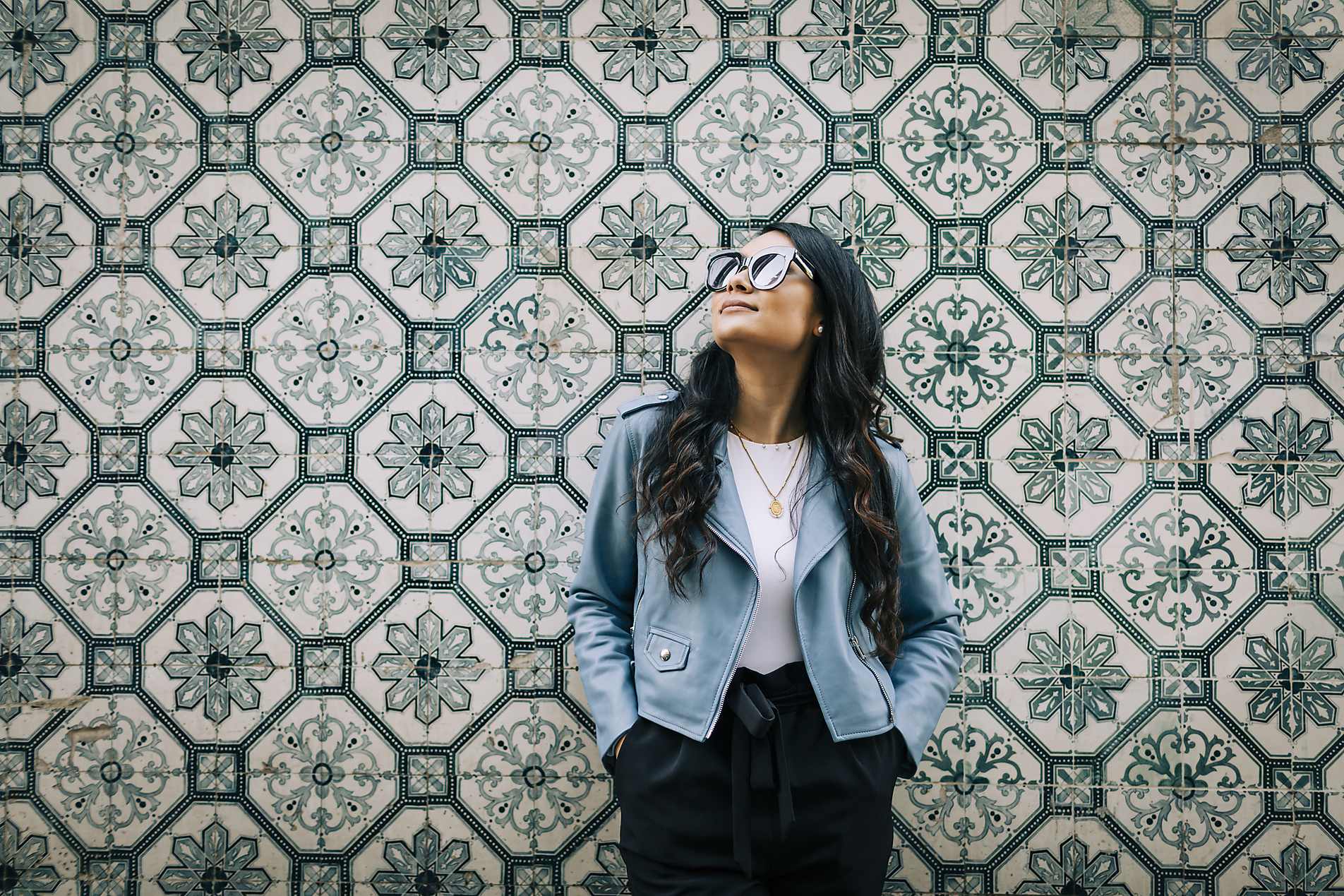 Stock image, royalty-free, Portrait of young woman wearing light blue leather jacket and sunglasses in front of Azulejo wall, Lisbon, Portugal, Alexandra C Ribeiro