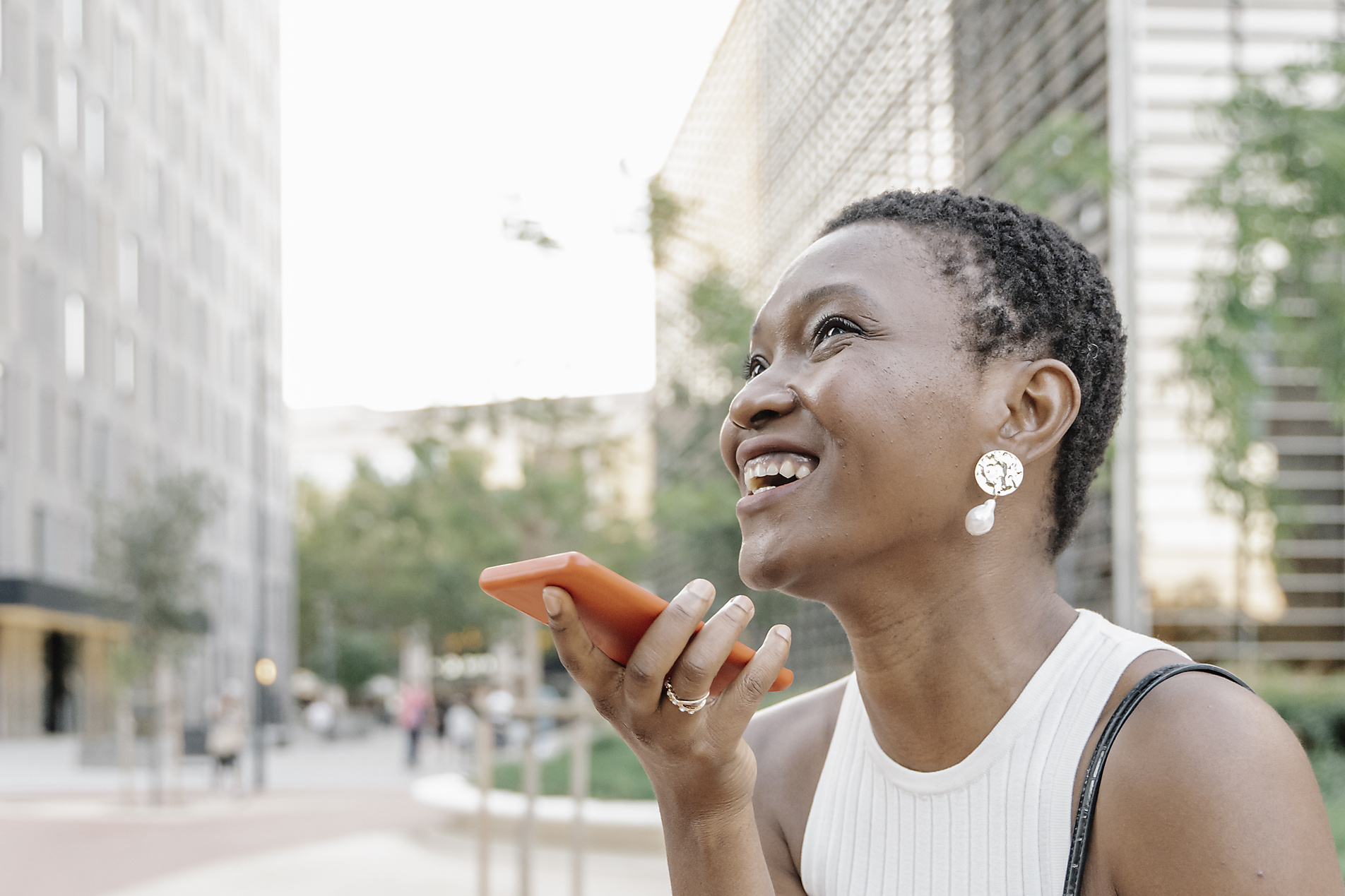 Stock image, royalty-free, Cheerful businesswoman sending voicemail through smart phone