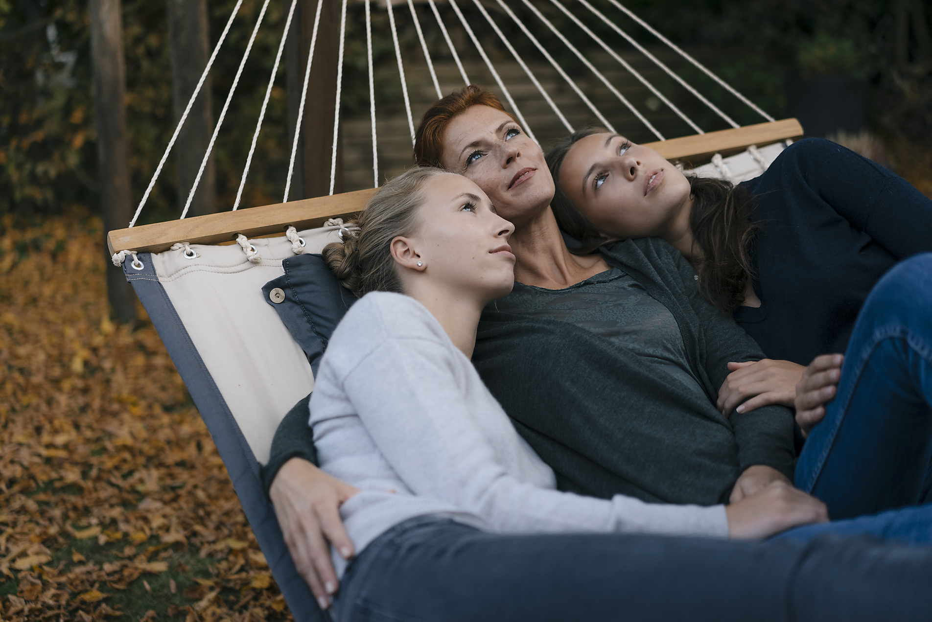Stock image, royalty-free, Mother with two teenage girls lying in hammock in garden in autumn, red hair, blonde hair, Joseffson
