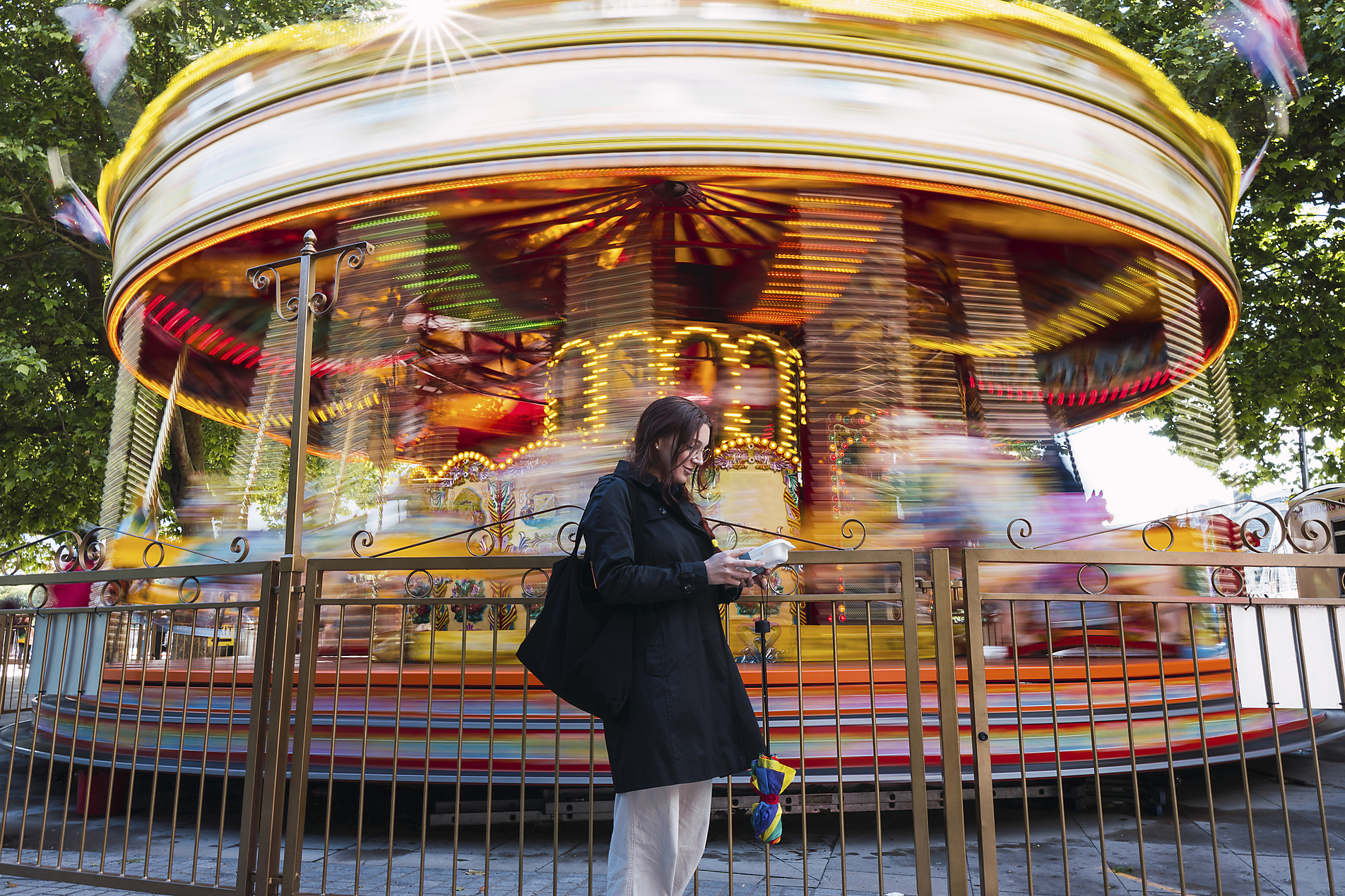 stock image, royalty-free, pau novell, Woman standing in front of carousel at amusement park