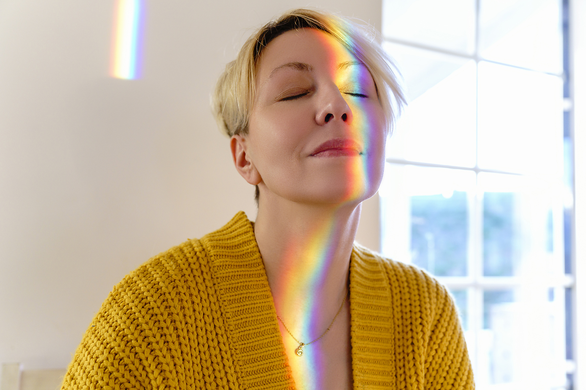 stock image, royalty-free, westend61, katharina mikhrin, Woman in yellow sweater with spectrum on face at home