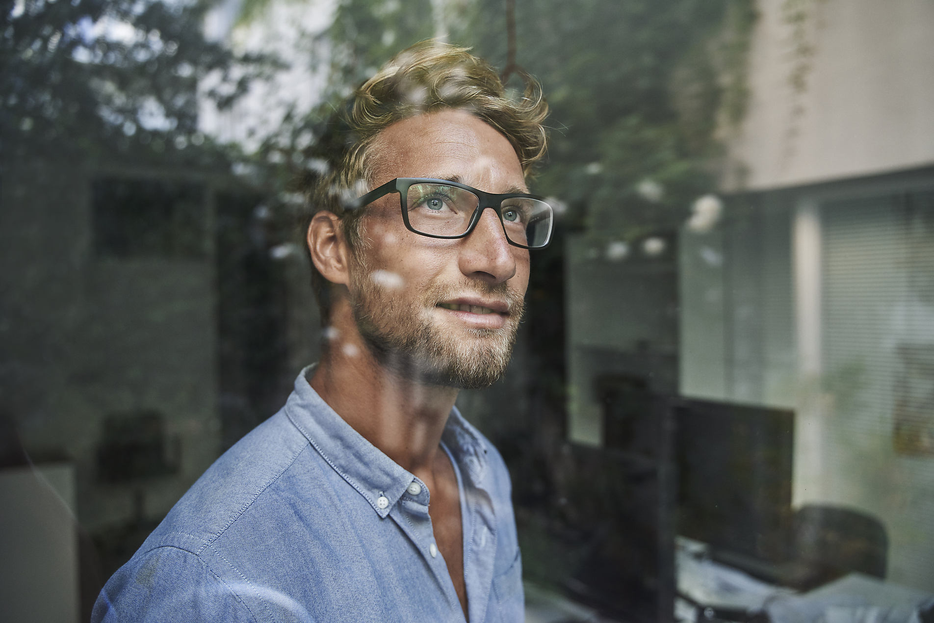 stock image, royalty-free, Casual young businessman behind windowpane in office