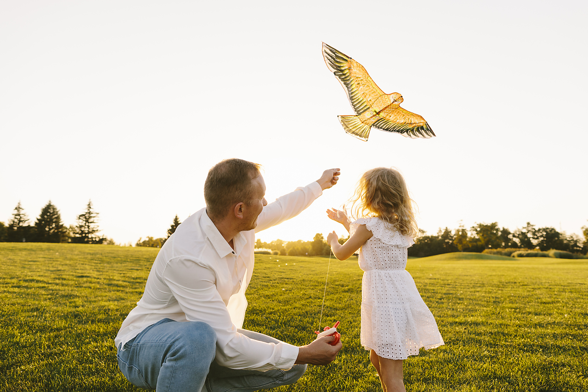 Stock image, royalty-free, Father teaching daughter to fly kite at sunset, Svetlana Iakusheva