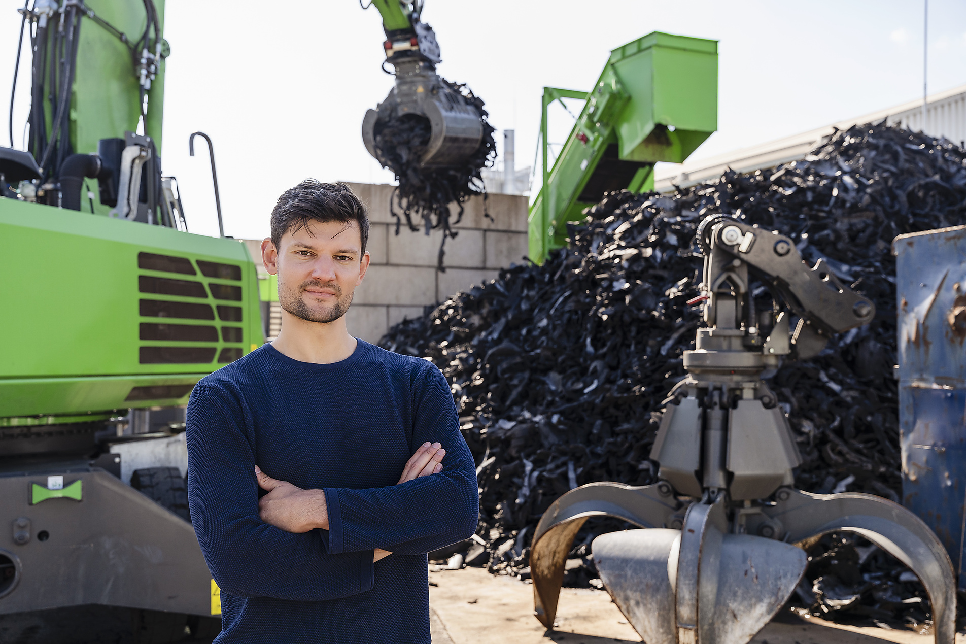 stock image, royalty-free, Businessman with arms crossed standing in front of excavator, Westend61, Pyrum Innovations, Recycling, Sustainability, eco-friendly, Industry, Daniel Ingold,