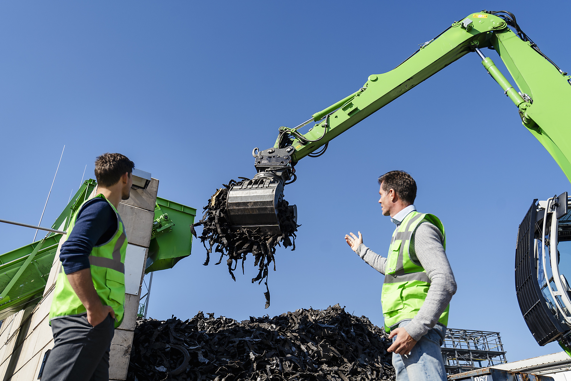 stock image, royalty-free, Mature man discussing over excavator with colleague at recycling center, Westend61, Pyrum Innovations, Recycling, Sustainability, eco-friendly, Industry, Daniel Ingold,
