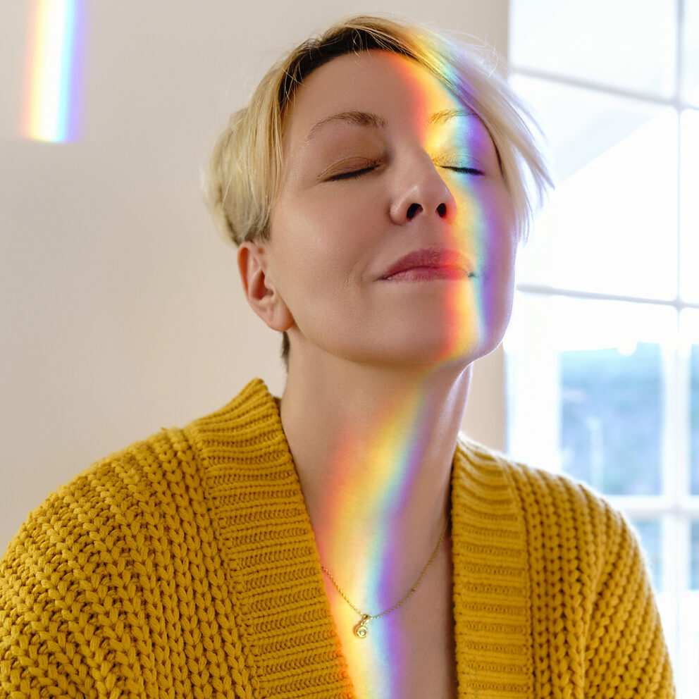 stock image, royalty-free, Woman in yellow sweater with spectrum on face at home, Westend61, Katharina Mikhrin