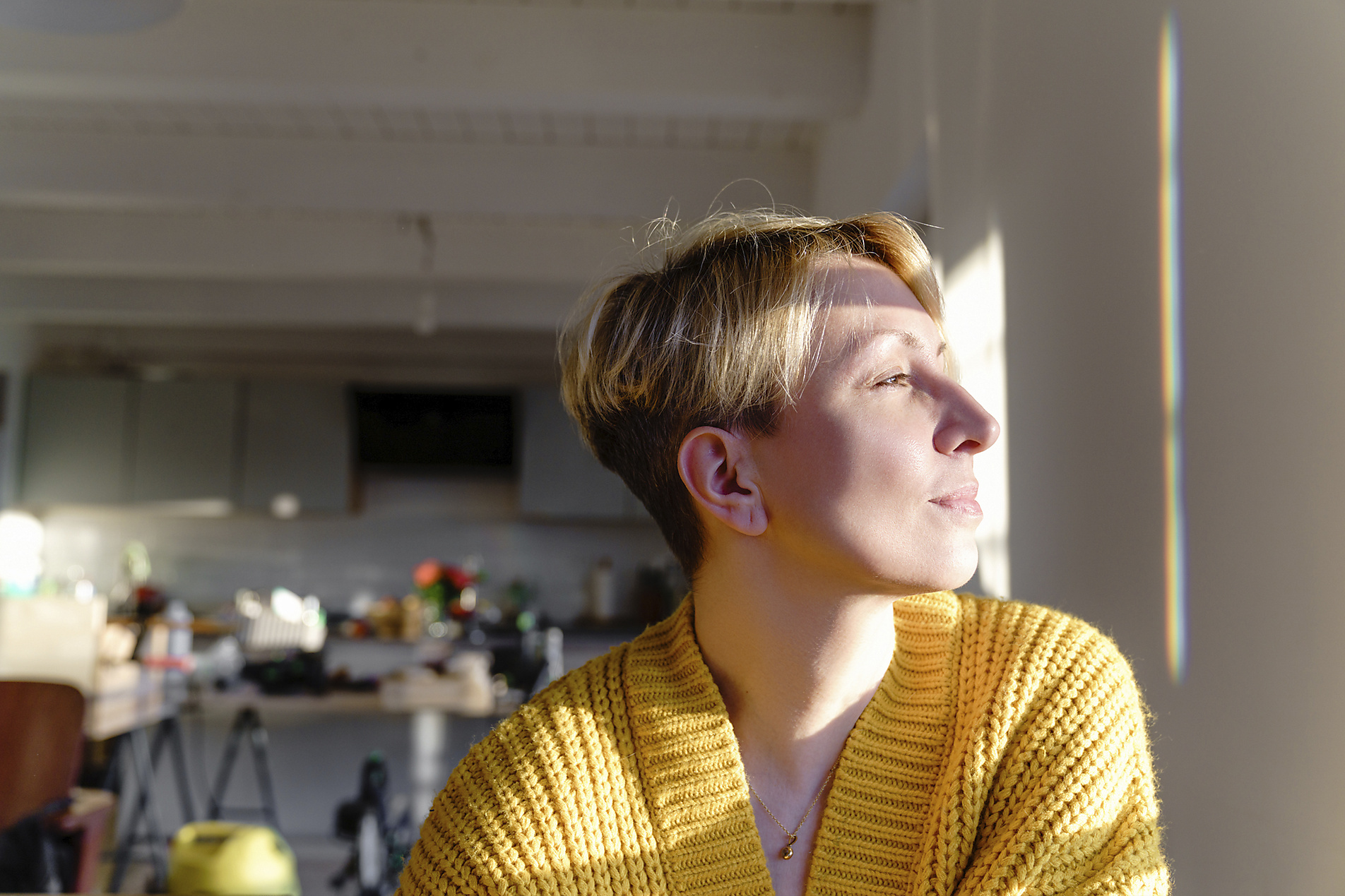 stock image, royalt-free, blonde Woman with short hair and yellow wool cardigan looking away at home during sunny day, Katharina Mikhrin, Westend61