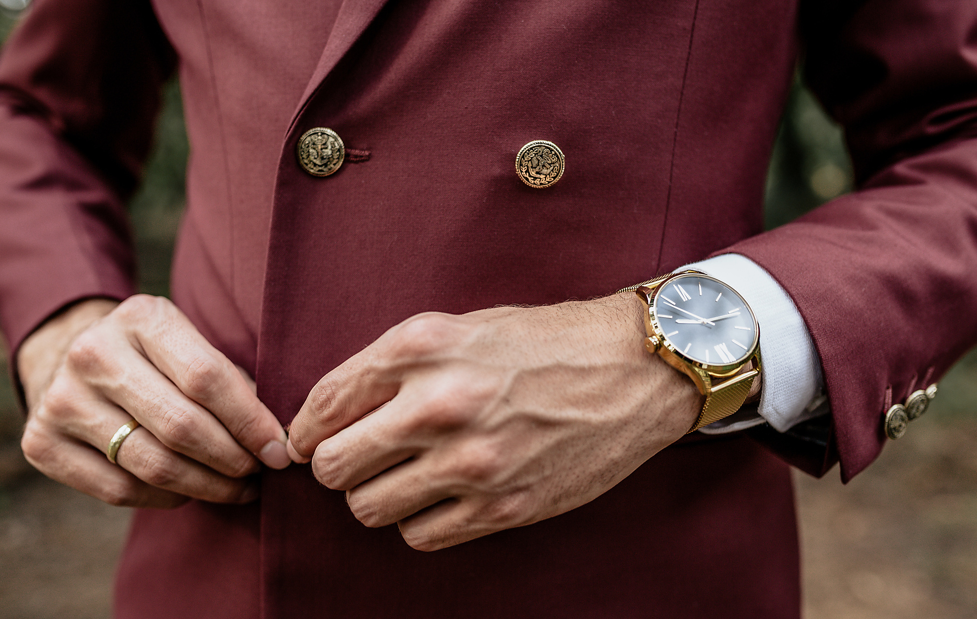 Stockfoto, lizenzfrei, Westend61, Nahaufnahme eines Mannes, der einen Anzug und eine goldene Uhr trägt und sein Jackett zuknöpft, Viva Magenta, Pantone Farbe 2023