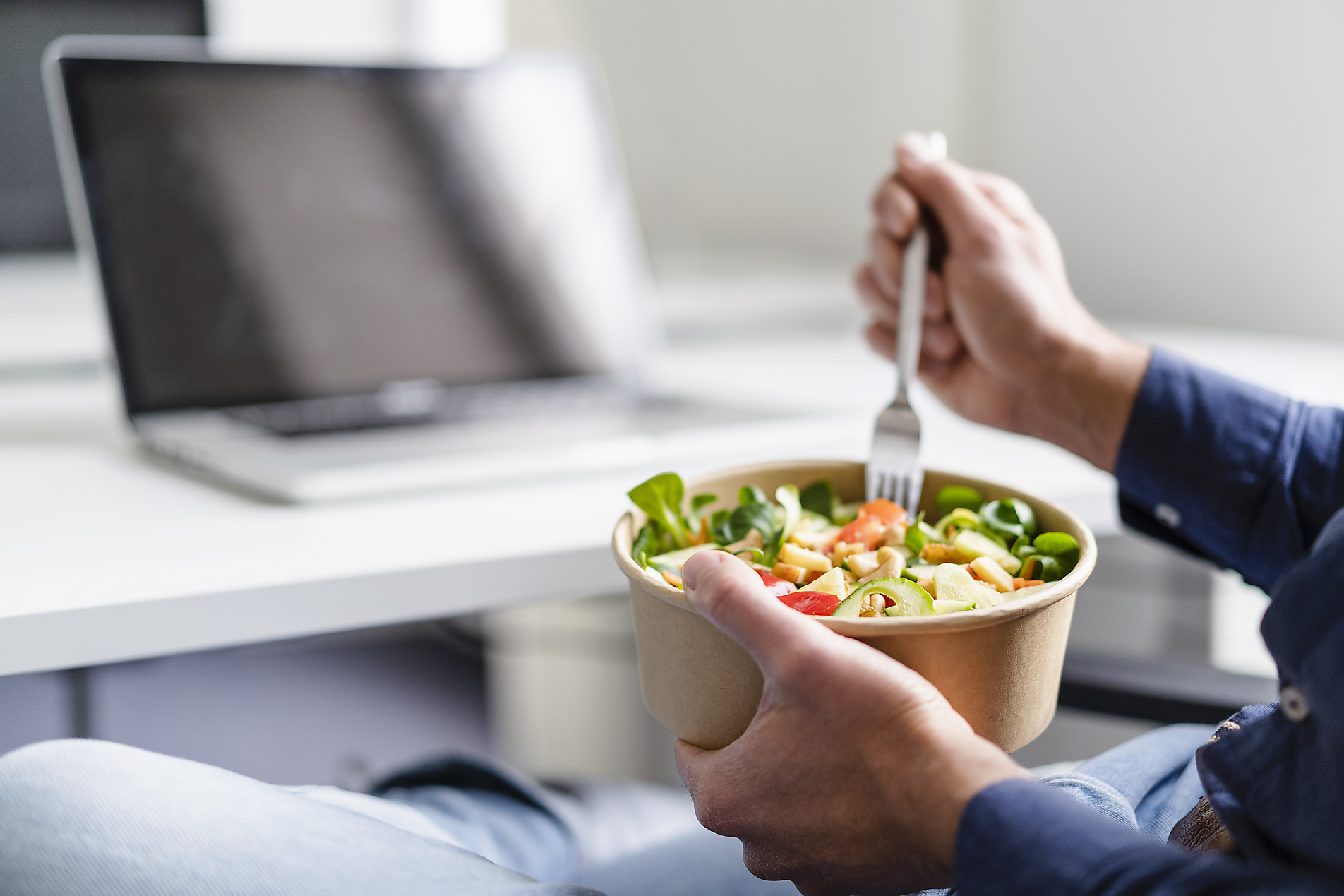 Businessman having salad in office, stock image, royalty-free, plant based food, vegetarian, vegan, sustainable, healthy eating