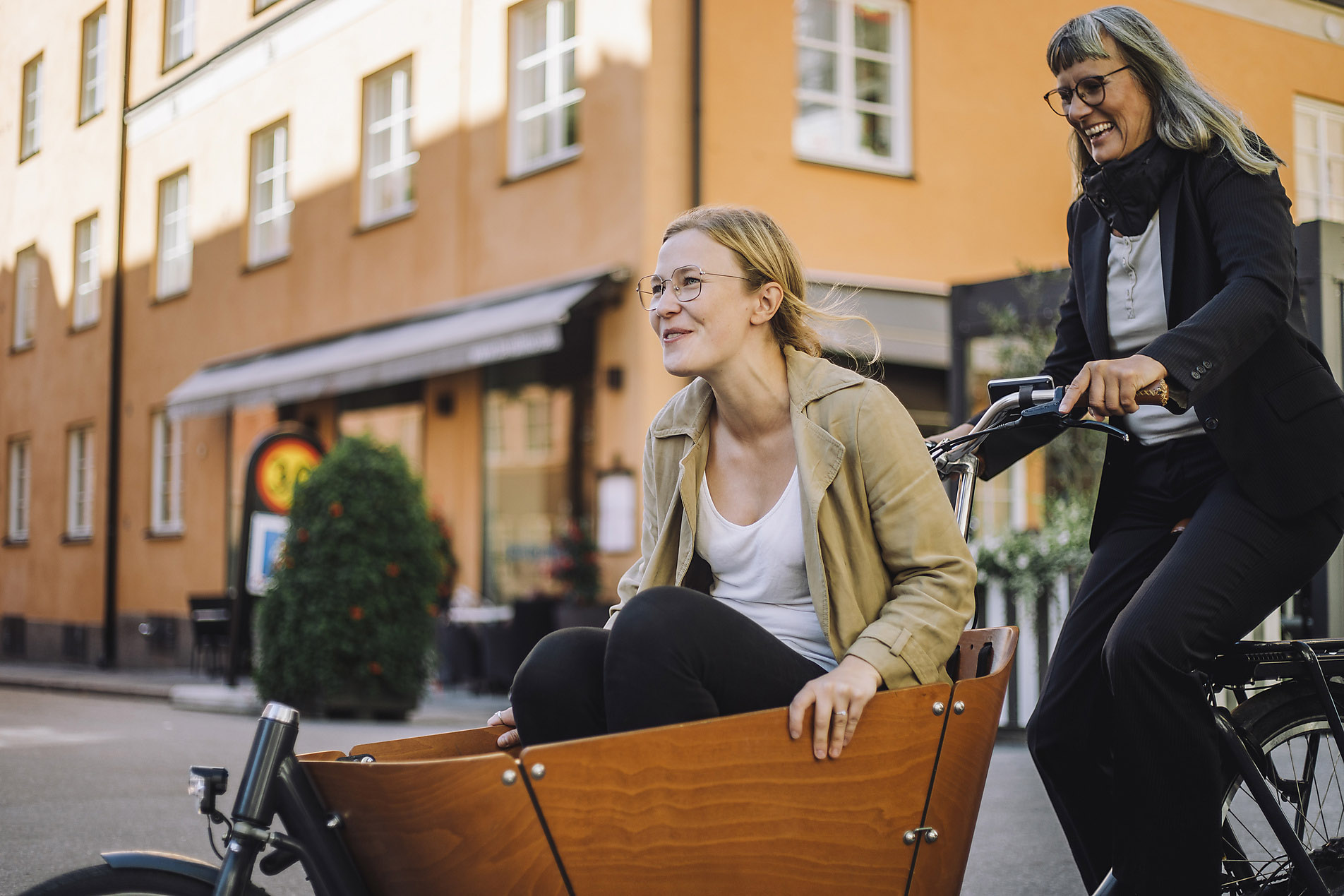 Happy mature business woman on a cargo bike with a colleague in the city, stock photo, royalty free, responsibility, mobility, action optimism, vision, stock photo, royalty free, visual trends 2023