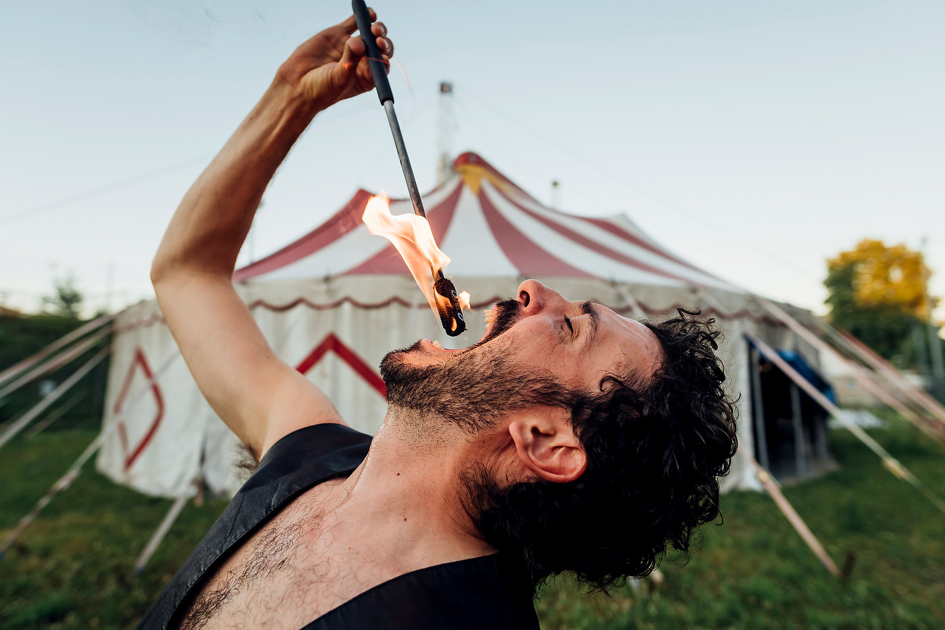 Stock photo, royalty free, male fire eater practicing in front of circus tent, safety, uncertainty, capital investment, investment, calculated risk, skill, uncertainty competence