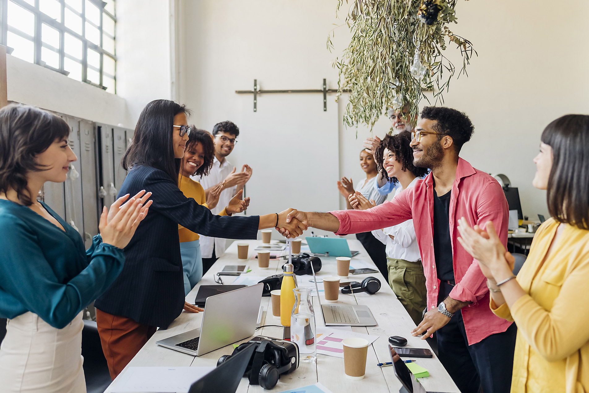 Businessman and businesswoman shaking hands with colleagues at work, stock photo, royalty free, resilience, business, enterprise, co-working, trend report 2023, visual trends