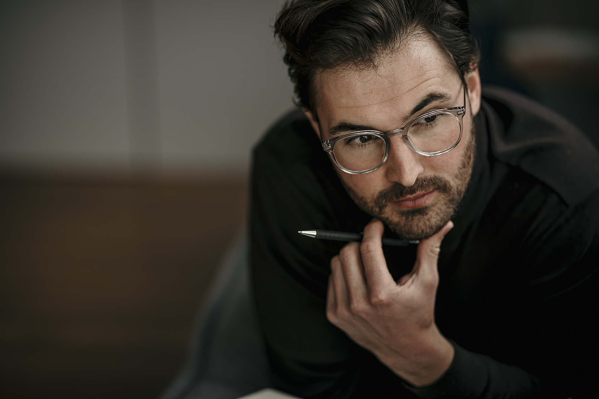 Serious businessman with hand on chin contemplating at home office, stock image, royalty-free, Malte Jäger, Westend61
