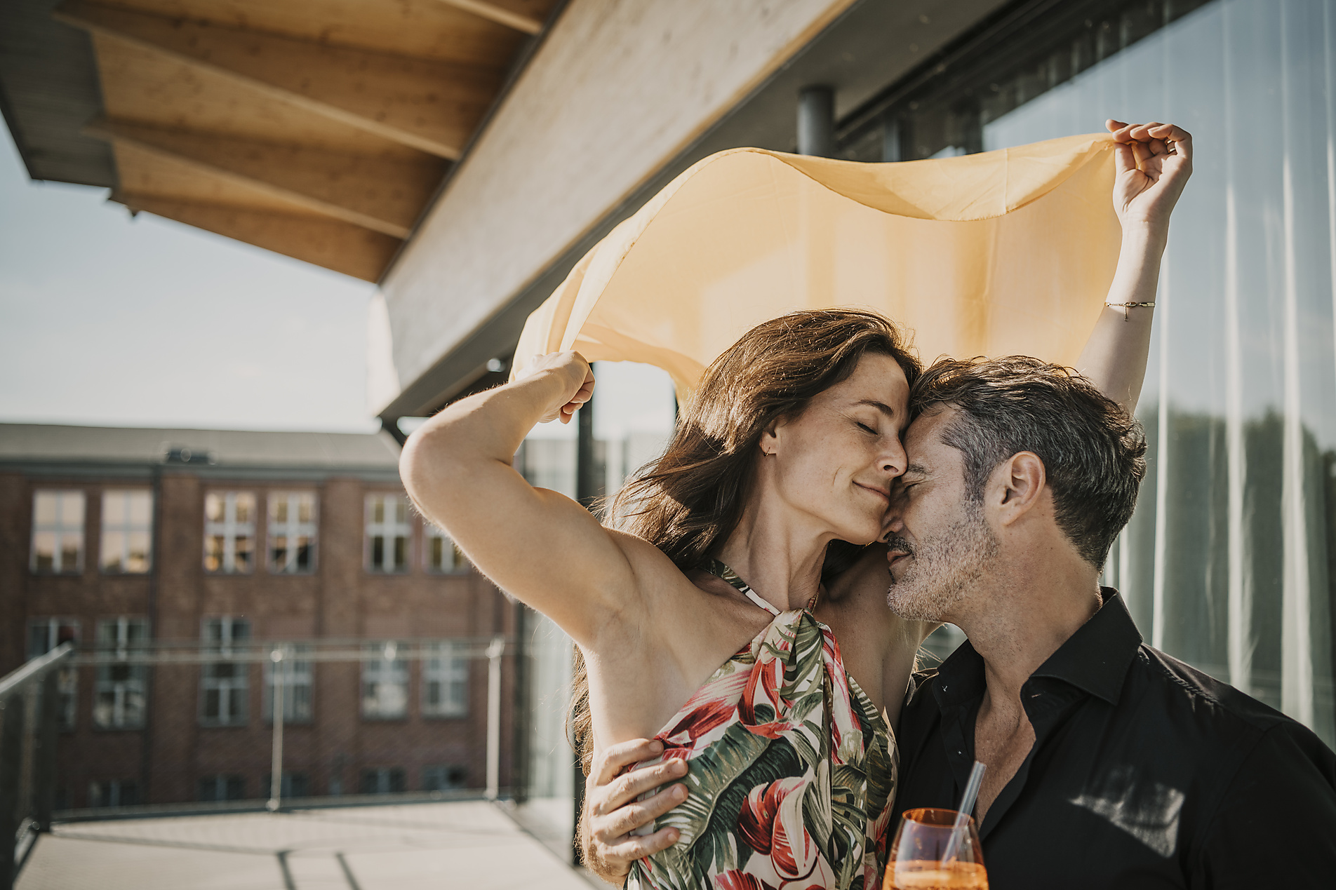 Affectionate couple embracing in balcony, stock image, royalty-free, westend61, malte jäger